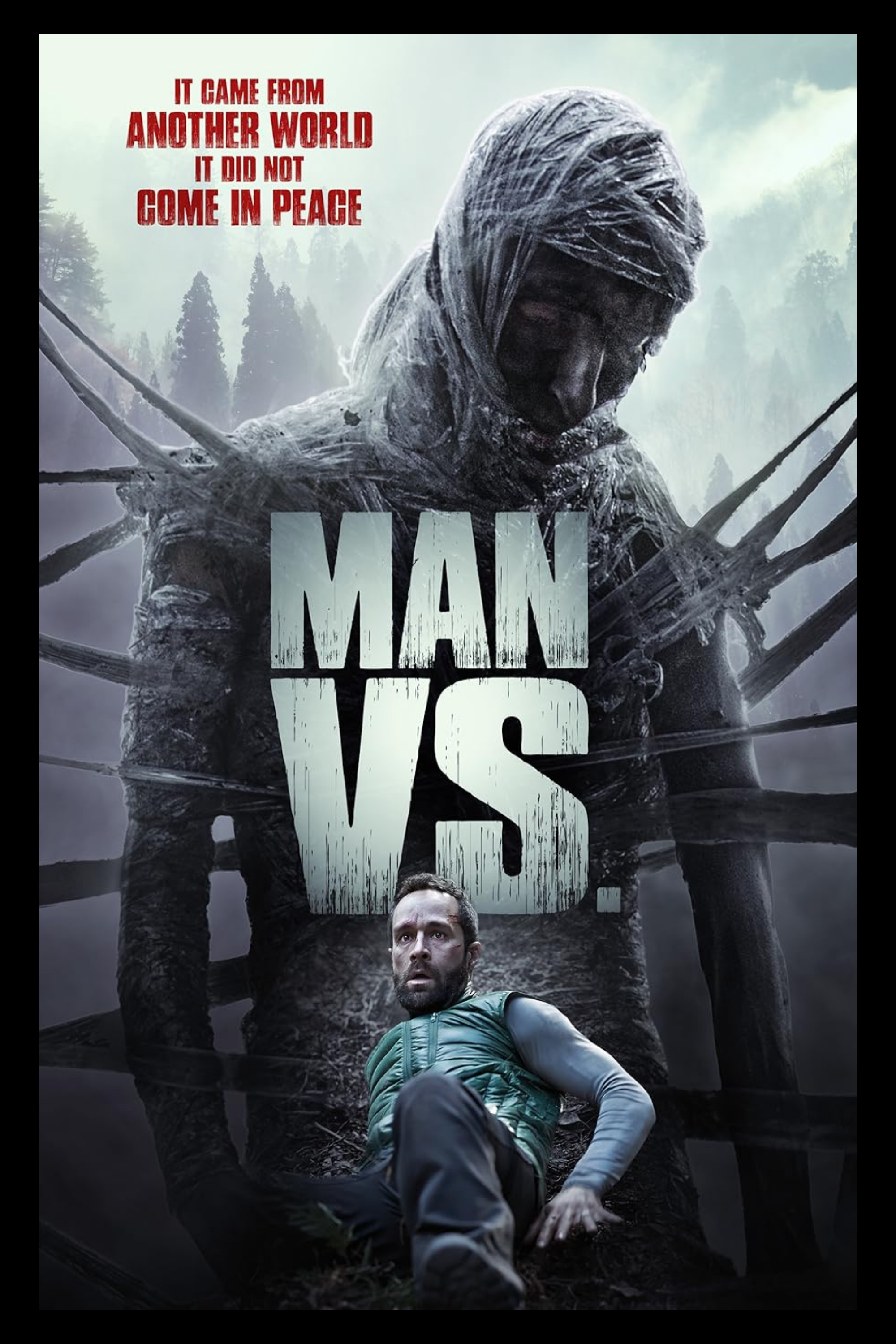 A movie poster for 'Man Vs,' showing a man sitting on the ground in the foreground and a large, monstrous figure with a hooded head and numerous tentacle-like limbs in the background, with a foggy forest behind it. The tagline reads 'It came from another world. It did not come in peace.'