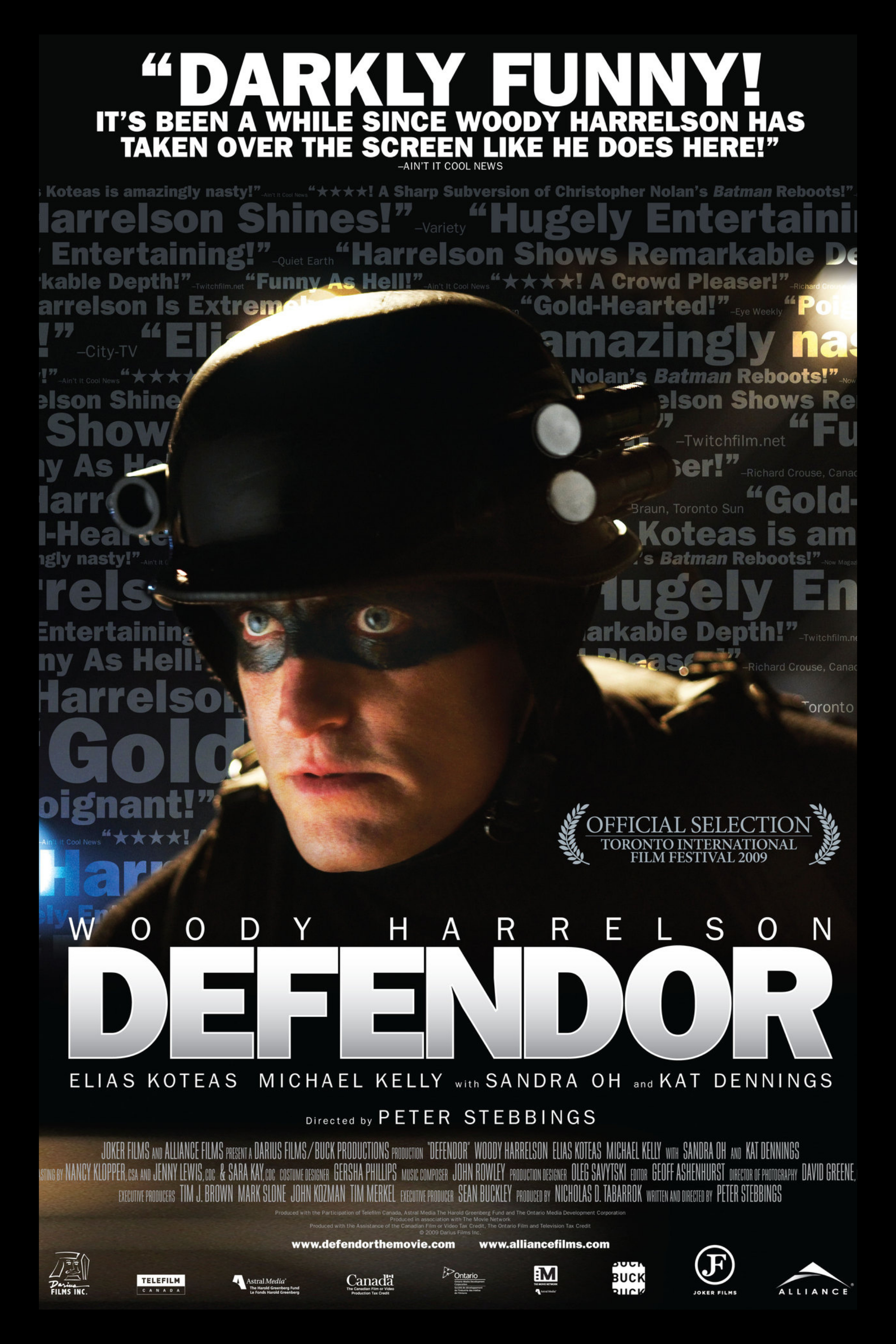 Movie poster for 'Defendor' featuring Woody Harrelson wearing a helmet with goggles, with background text in blue and white.