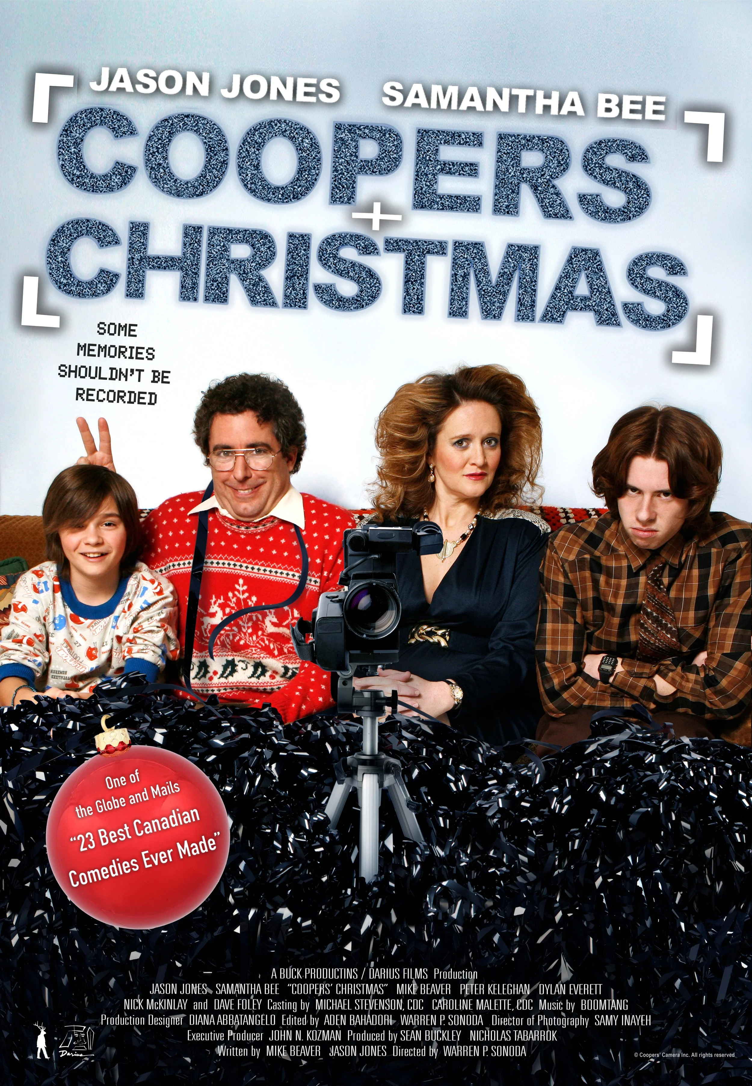 Poster for the movie "Coopers Christmas" featuring four characters sitting on a couch with Christmas decorations and a camera in front of them. The title is displayed prominently at the top, with the names Jason Jones and Samantha Bee above it. A red ornament with white text highlights the film as one of the best Canadian comedies.