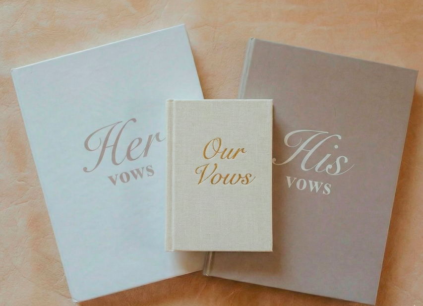 Three vow books labeled His, Her, and Our Vows; symbolizing the dedicated service promise of a bridal doula in Leesburg VA