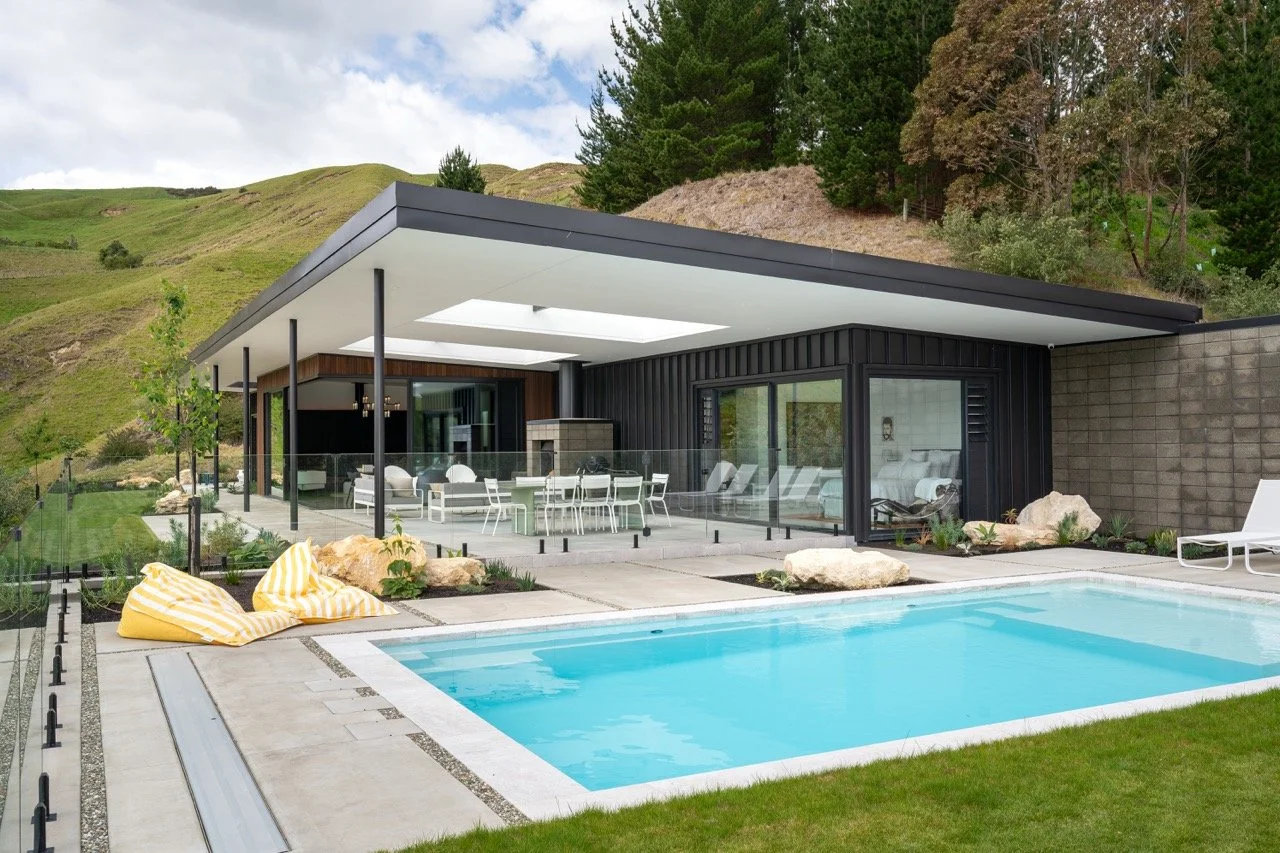 Modern house with a swimming pool in a green landscape.