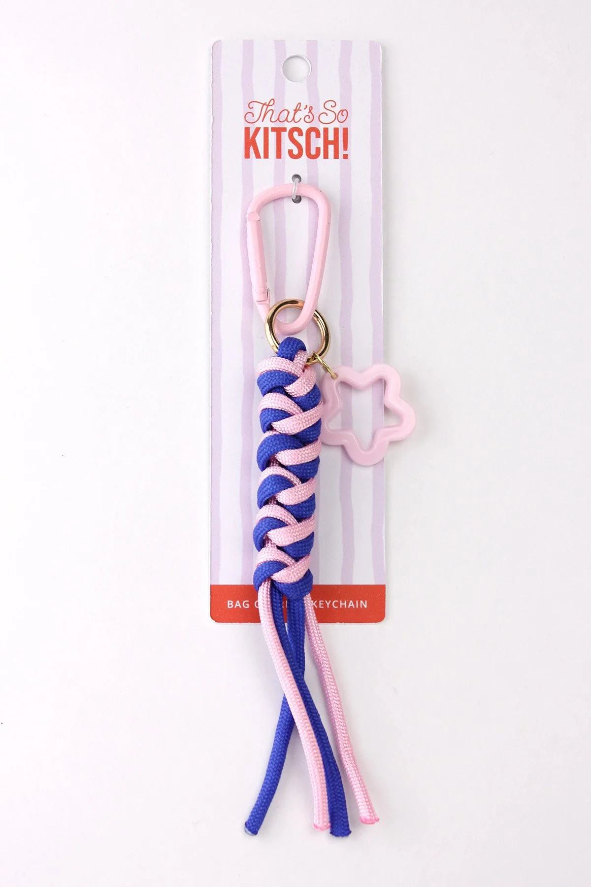 A keychain with a pink carabiner attached to a striped fabric decorate in pink and blue, hanging from a cardboard backing labeled 'That's So KITSCH!'