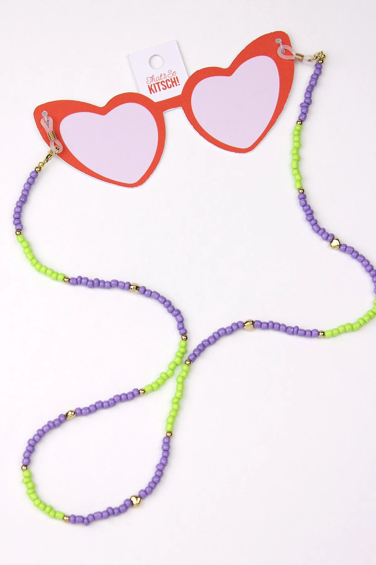 Colorful beaded sunglasses chain with purple and green beads, attached to red heart-shaped sunglasses with a tag reading "That's So KITSCH!"