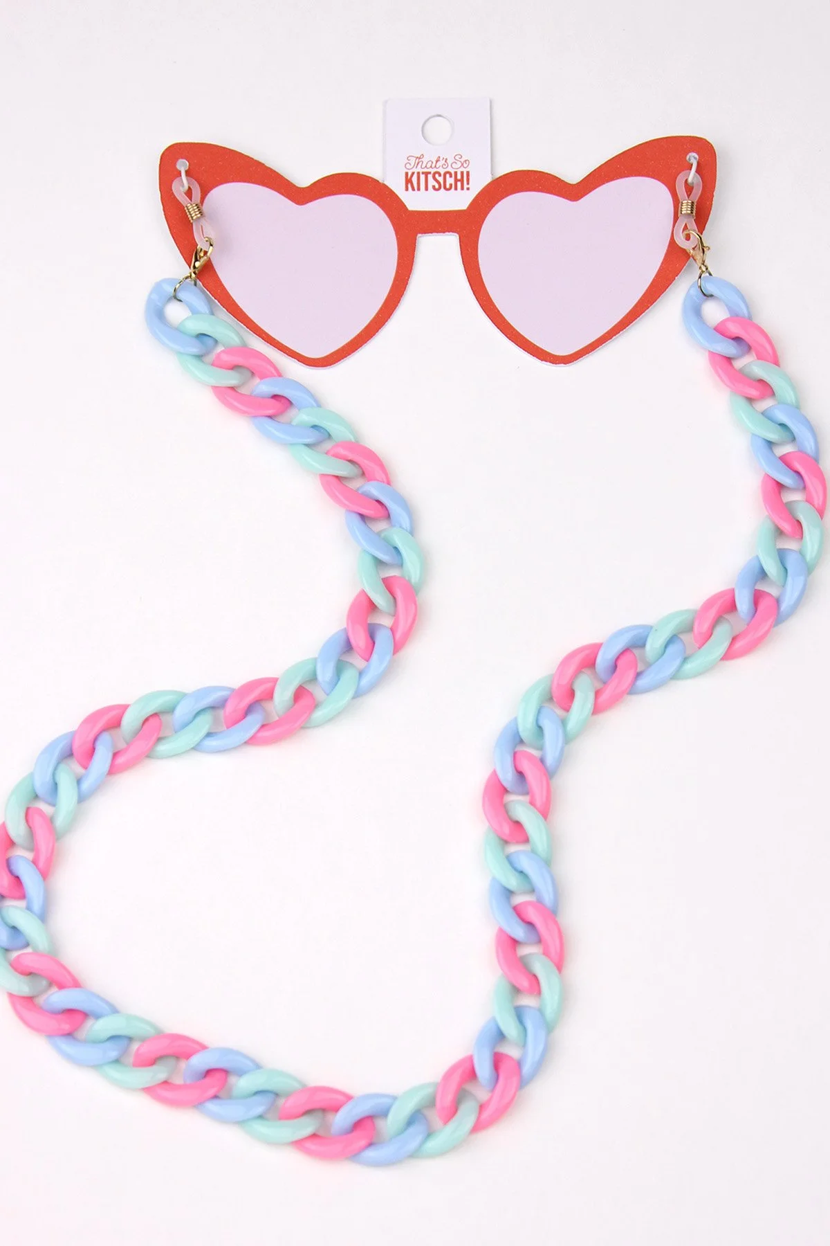 Colorful plastic chain necklace and sunglasses with heart-shaped lenses on white background.