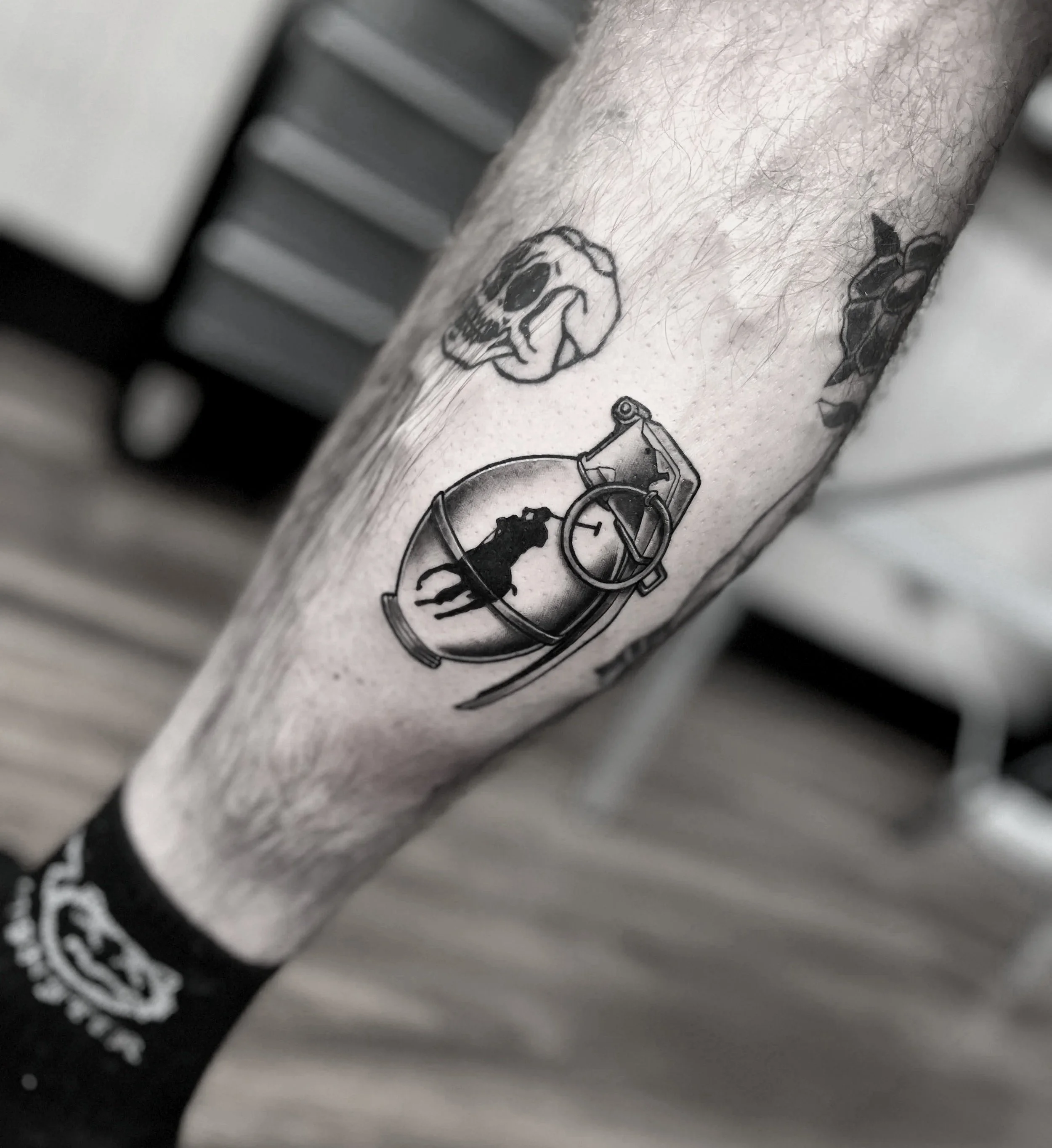 Tattoo on calf featuring a Polo Ralph Lauren branded grenade.