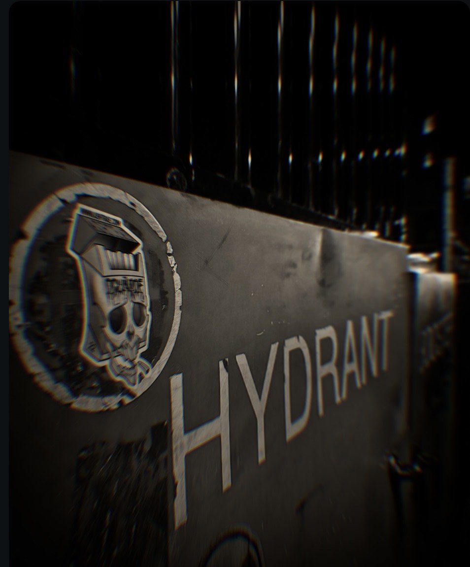 A sign with the words 'HYDRANT' and a skull logo, partially visible, mounted on a wall near a black metal fence.