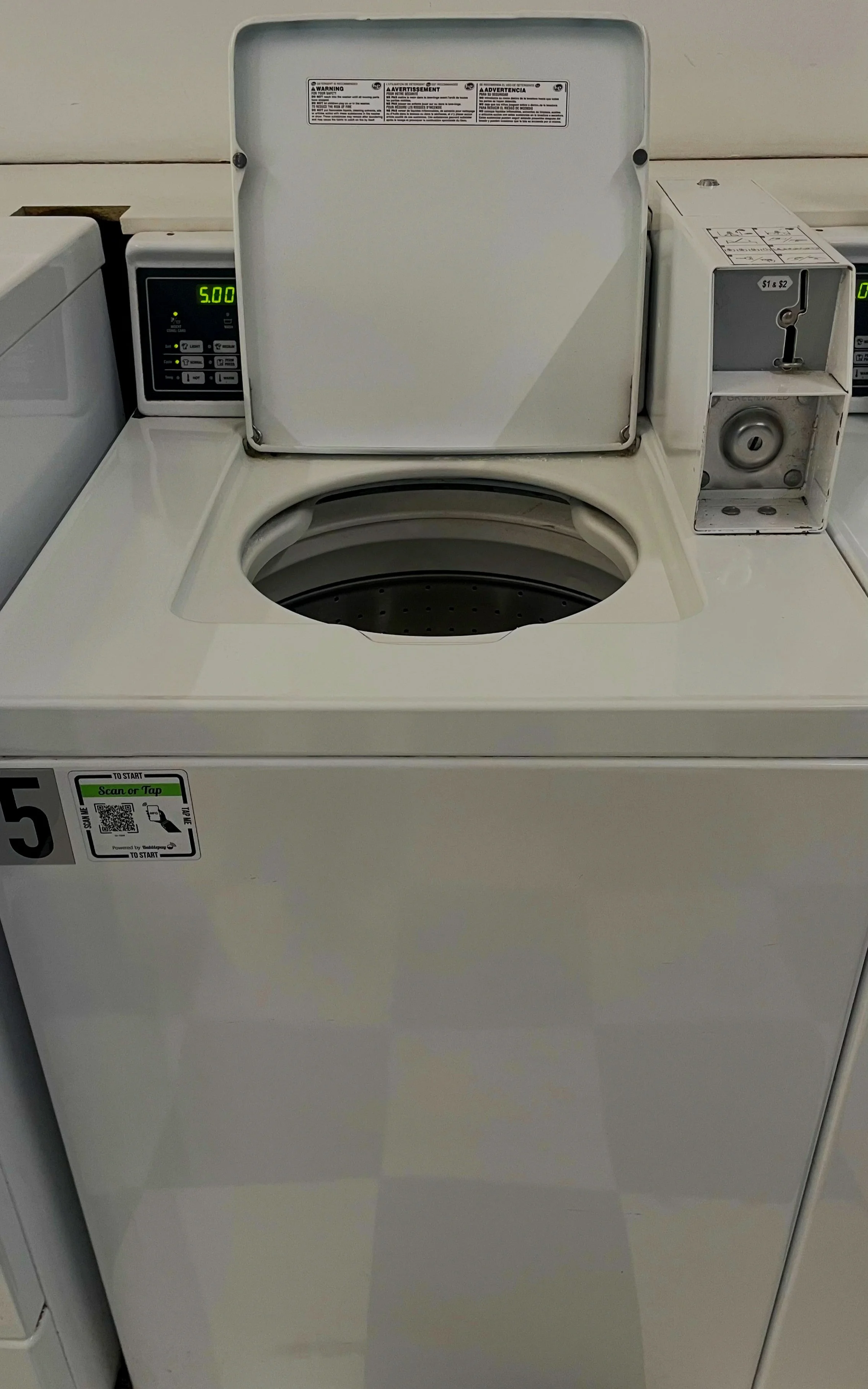White automatic washing machine with open lid, digital display showing 5.00, and card payment slot on the right side.