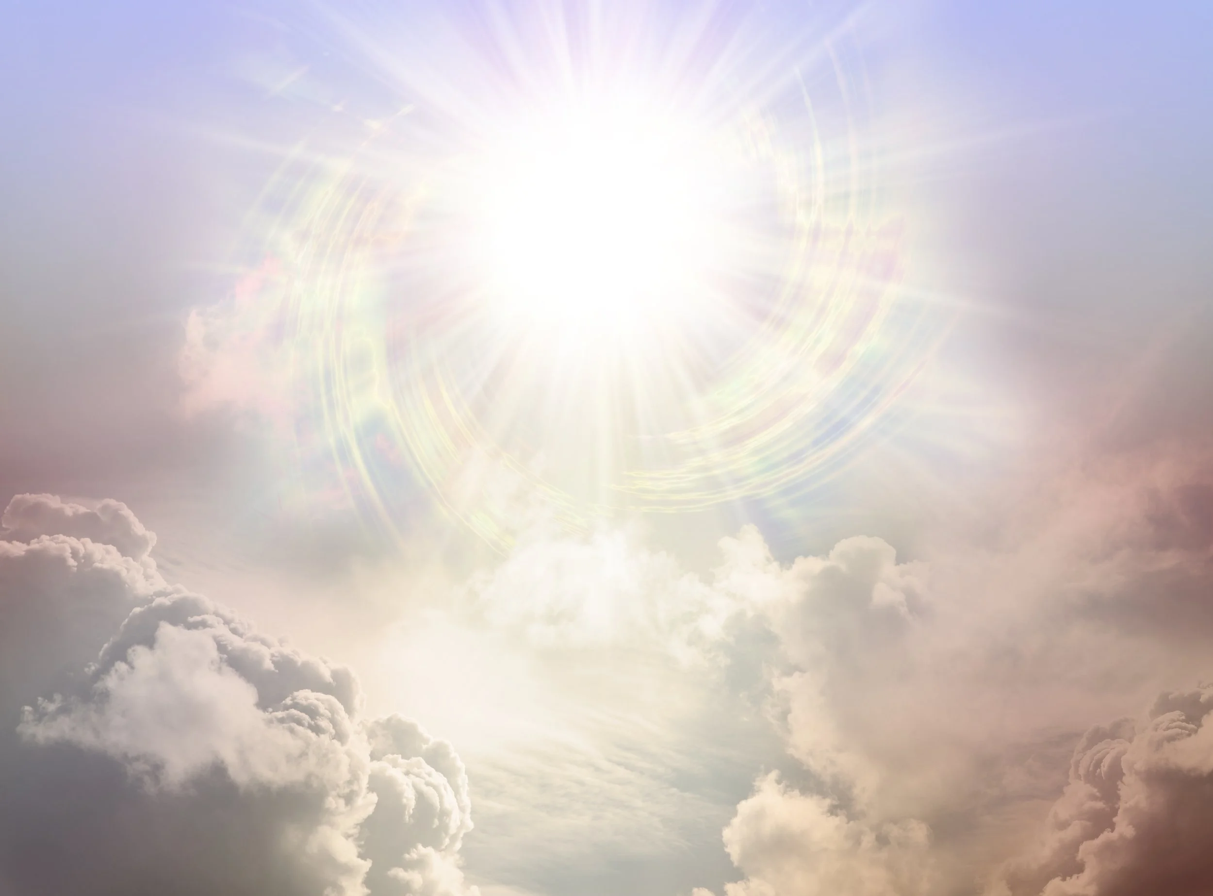 Bright sun shining in a mostly cloudy sky with lens flare and radiant heat effects.
