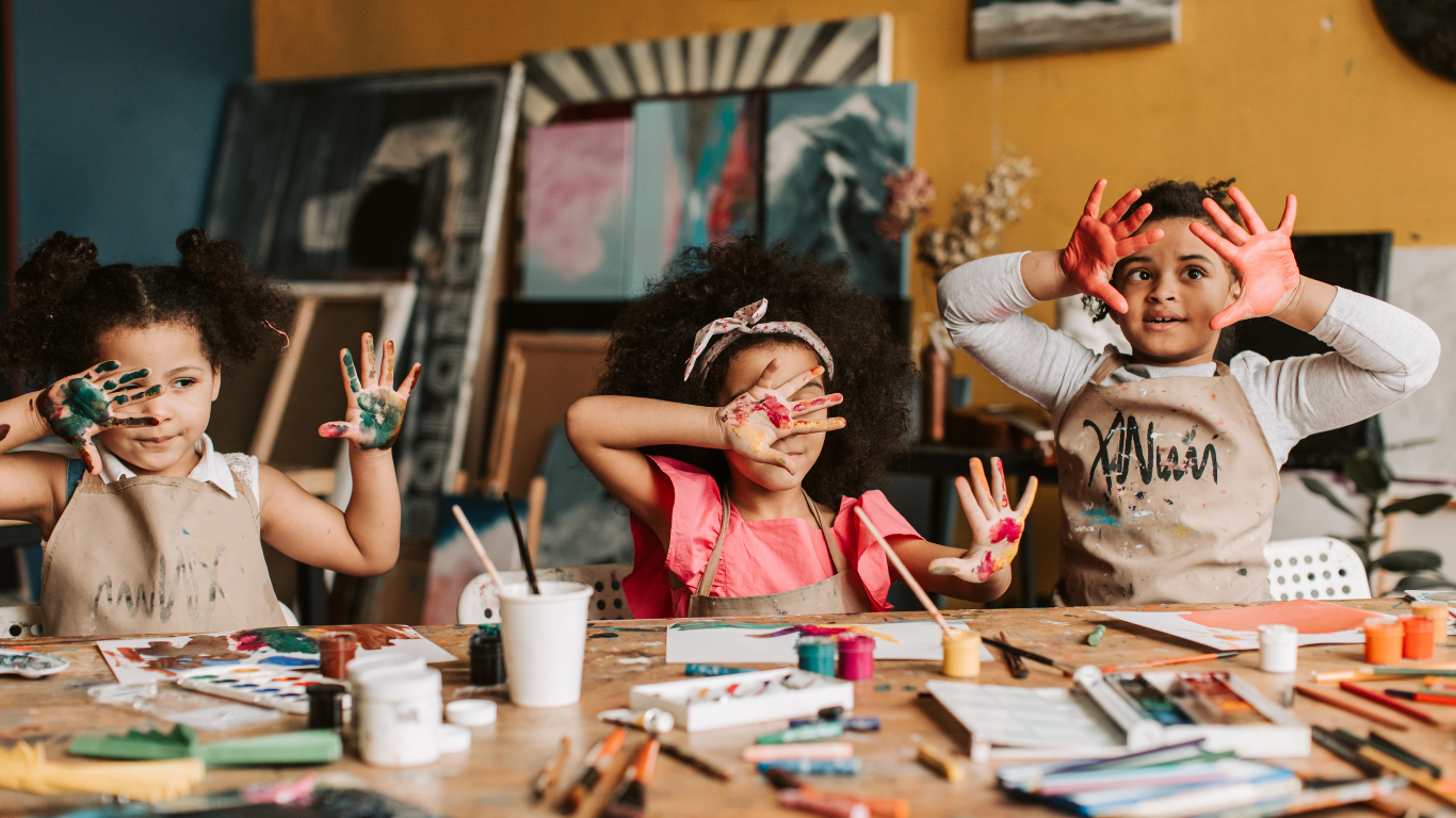 Children doing a creative art activity with paint during a kids yoga and mindfulness class, exploring creativity and self-expression.