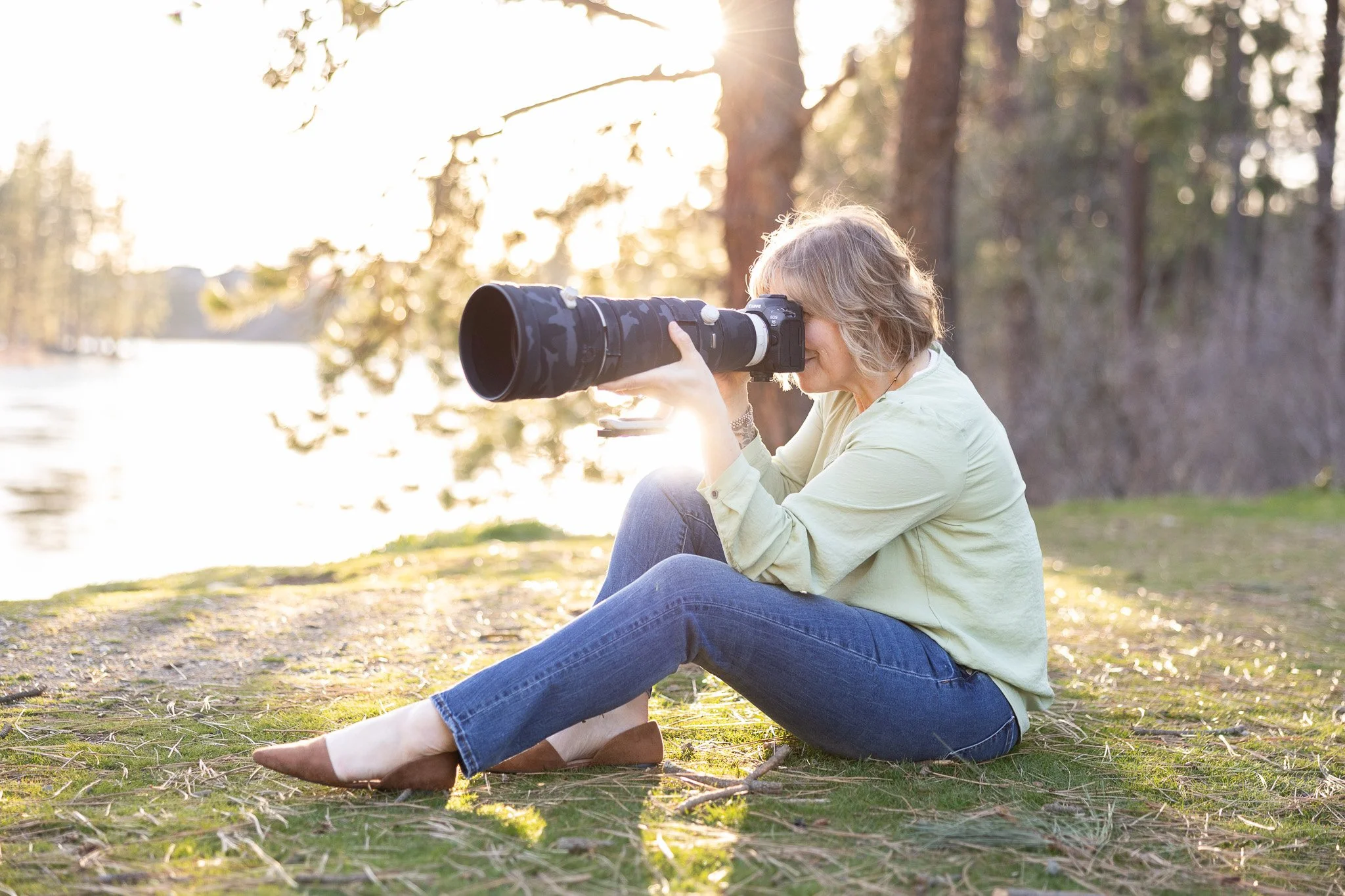 Desiree Hildenbrand sitting on the ground holding a camera.