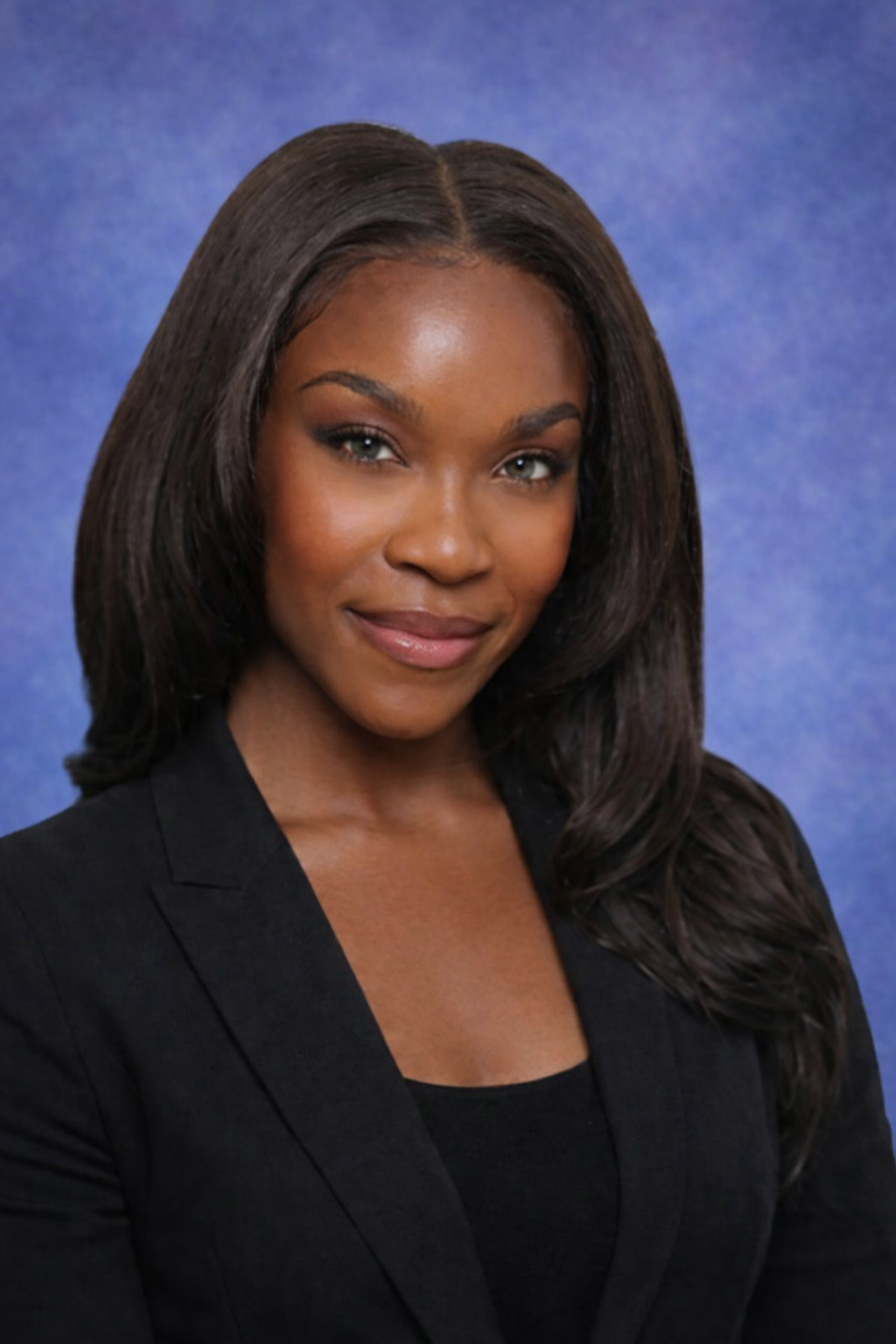 Professional woman with long dark hair wearing a black blazer and smiling