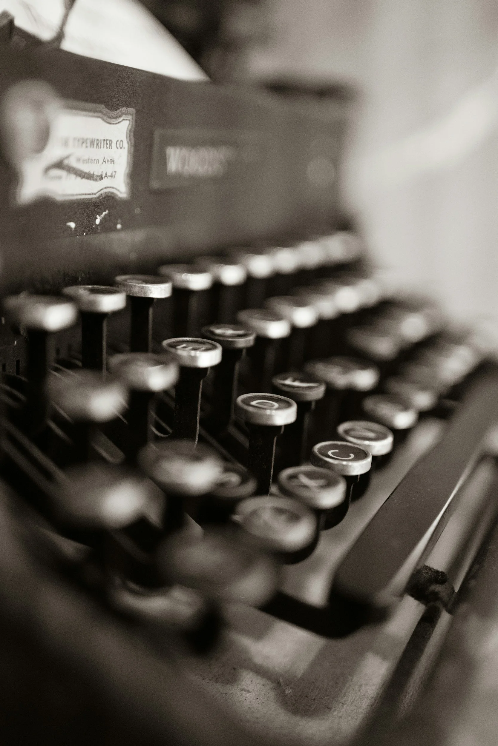 Close-up black and white photo of a vintage typewriter keyboard with round keys.