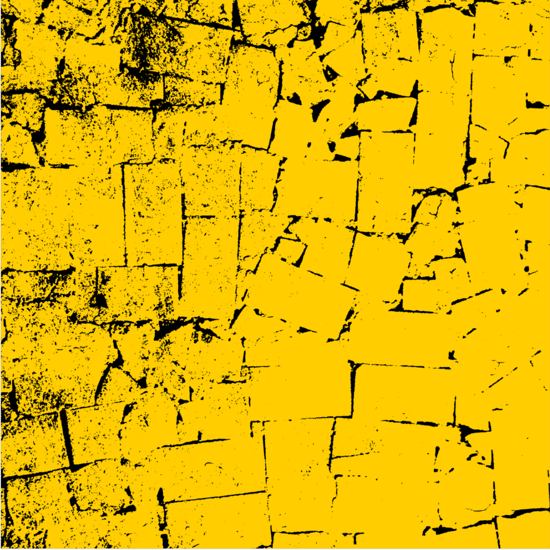 Close-up of a yellow brick wall with black cracks and mortar lines.
