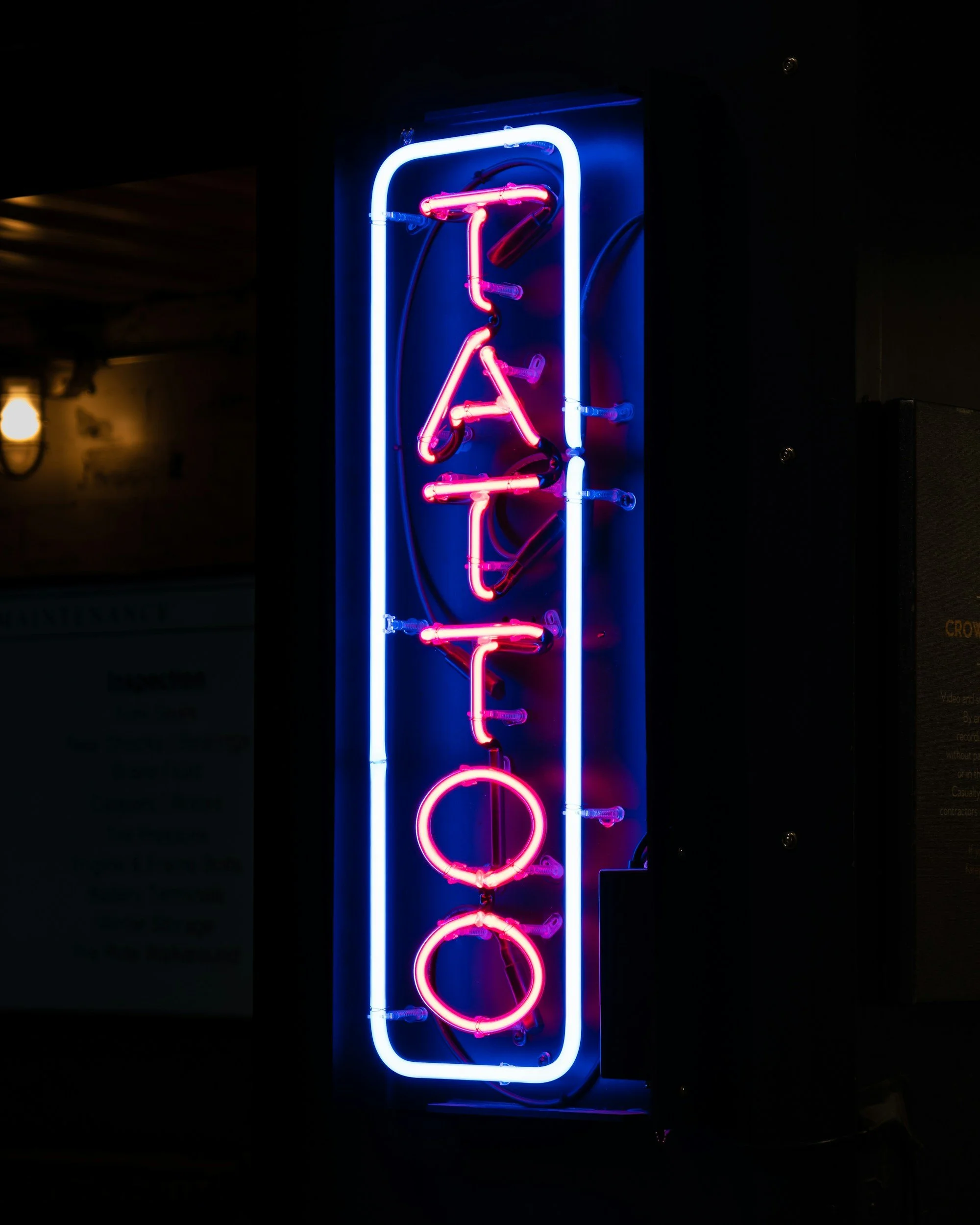 neon tattoo design dimly lit area with a bright neon tattoo sign. are tattoo shops all walkin stores?