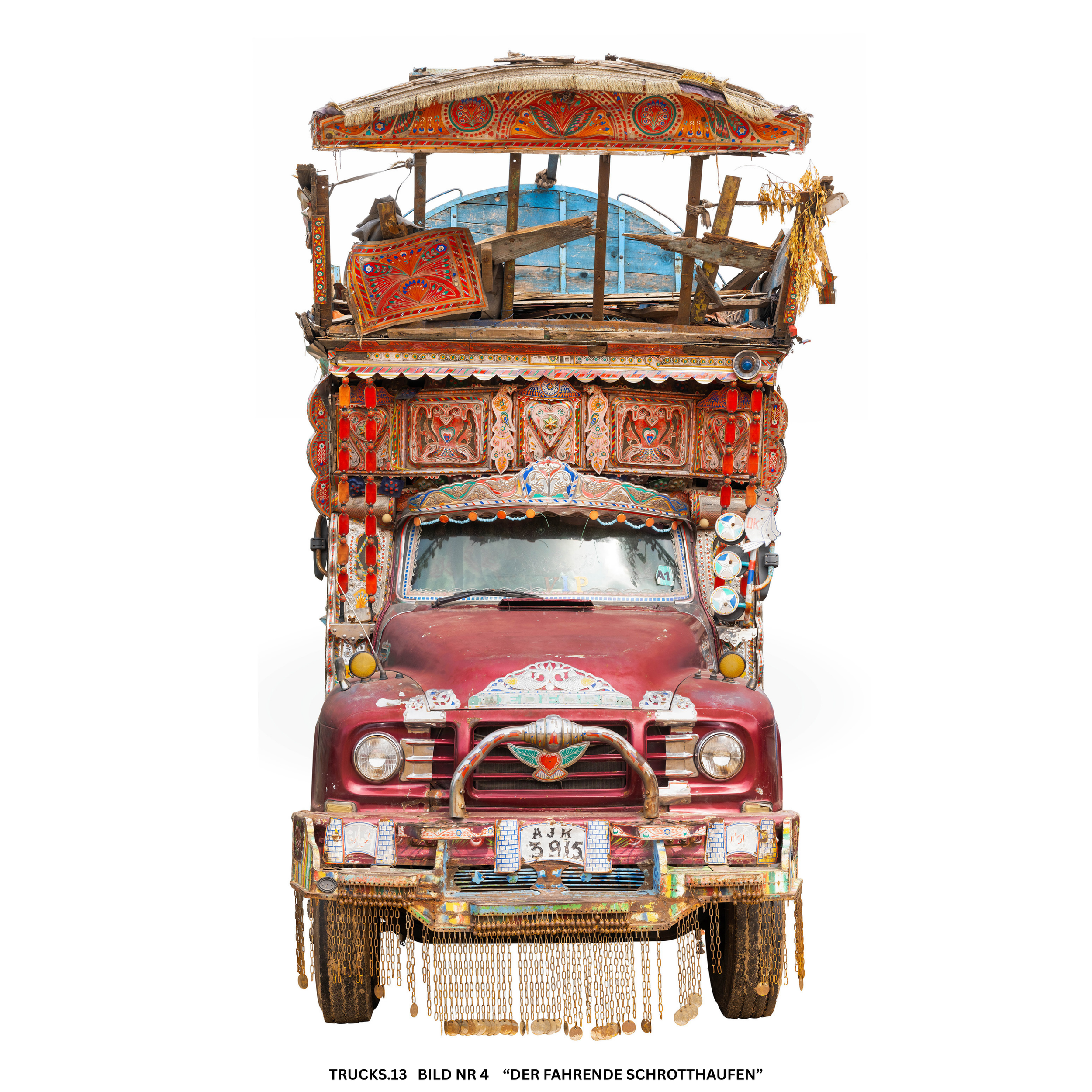 Ein kunstvoll bemalter, alter, zerbrochener Lastwagen, der als Kunstinstallation dient. Der Lastwagen ist reich verziert mit bunten Mustern, Perlen und hängenden Dekorationen.