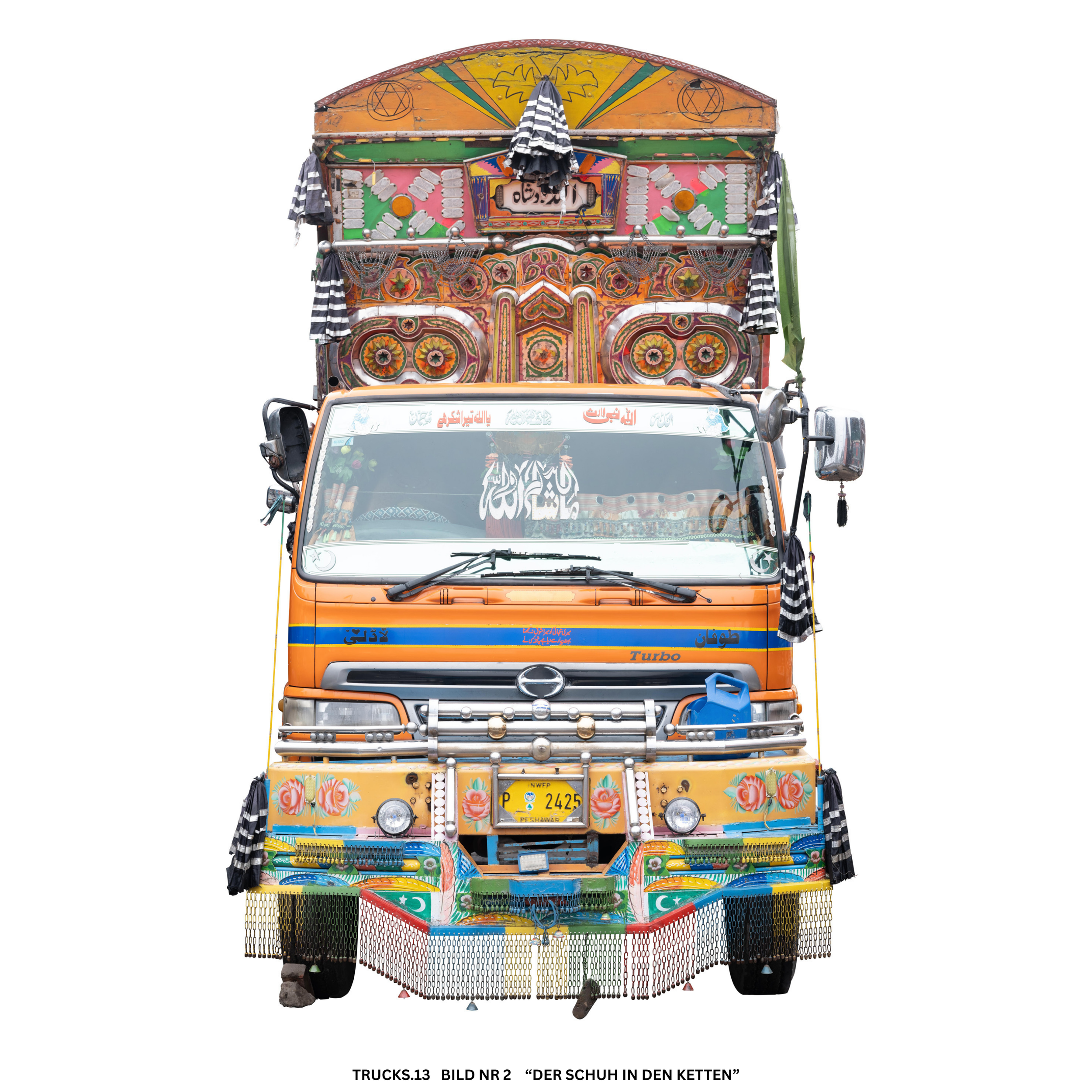 Ein bunt dekorierter LKW mit traditionellen Mustern und Stoffen, verziert mit Flaggen und metallischen Elementen, darunter ein Kettenvorhang am unteren Rand.