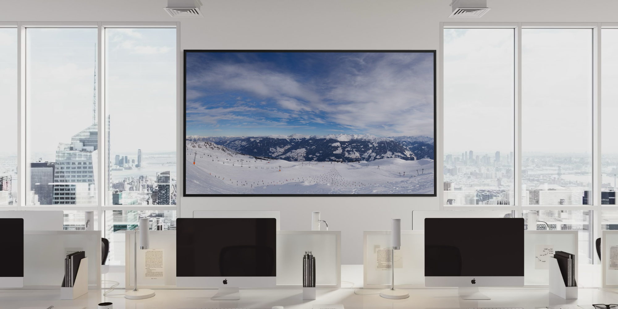 Ein modernes Büro mit weißen Arbeitsplätzen und Computern, riesigen Fenstern mit Blick auf eine Stadt, und einem großen Bildschirm, der eine verschneite Berglandschaft zeigt.