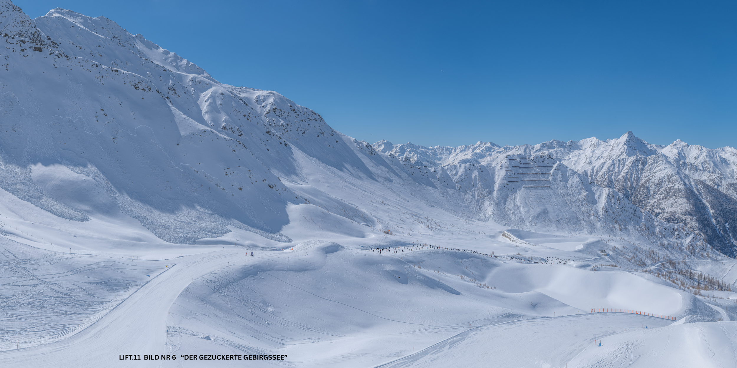 Schneebedeckte Berge und Skipiste im Gebirge bei schönem blauen Himmel.