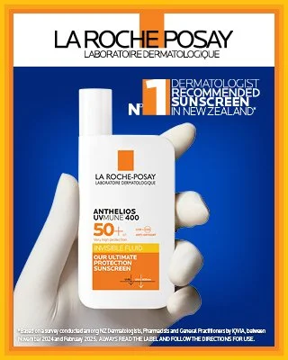 Bottle of La Roche-Posay Anthelios UVMUNE 400 SPF 50 sunscreen being held by a gloved hand, with a blue background and packaging information.