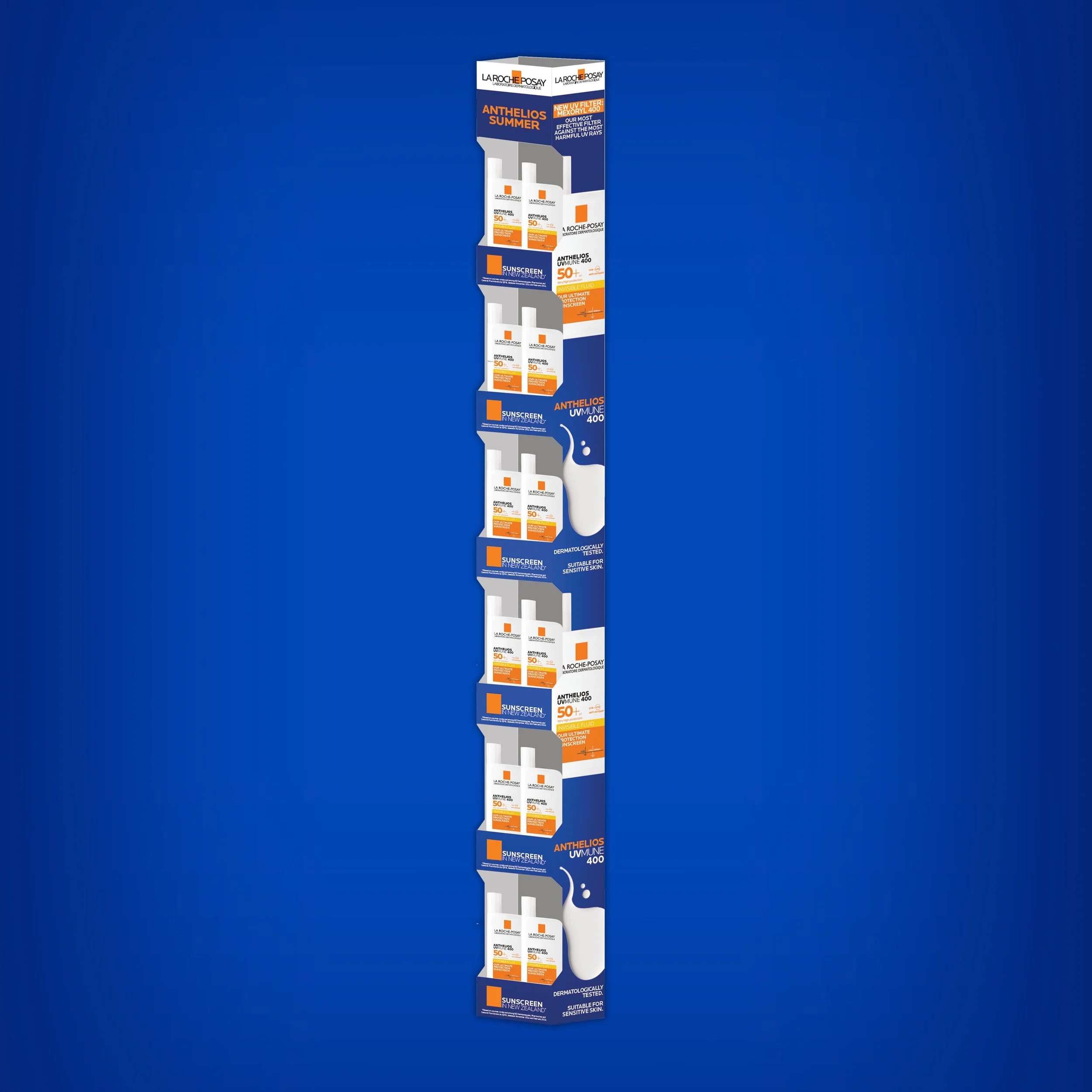 Display stand with La Roche Posay sunscreen products in a store against a blue background.