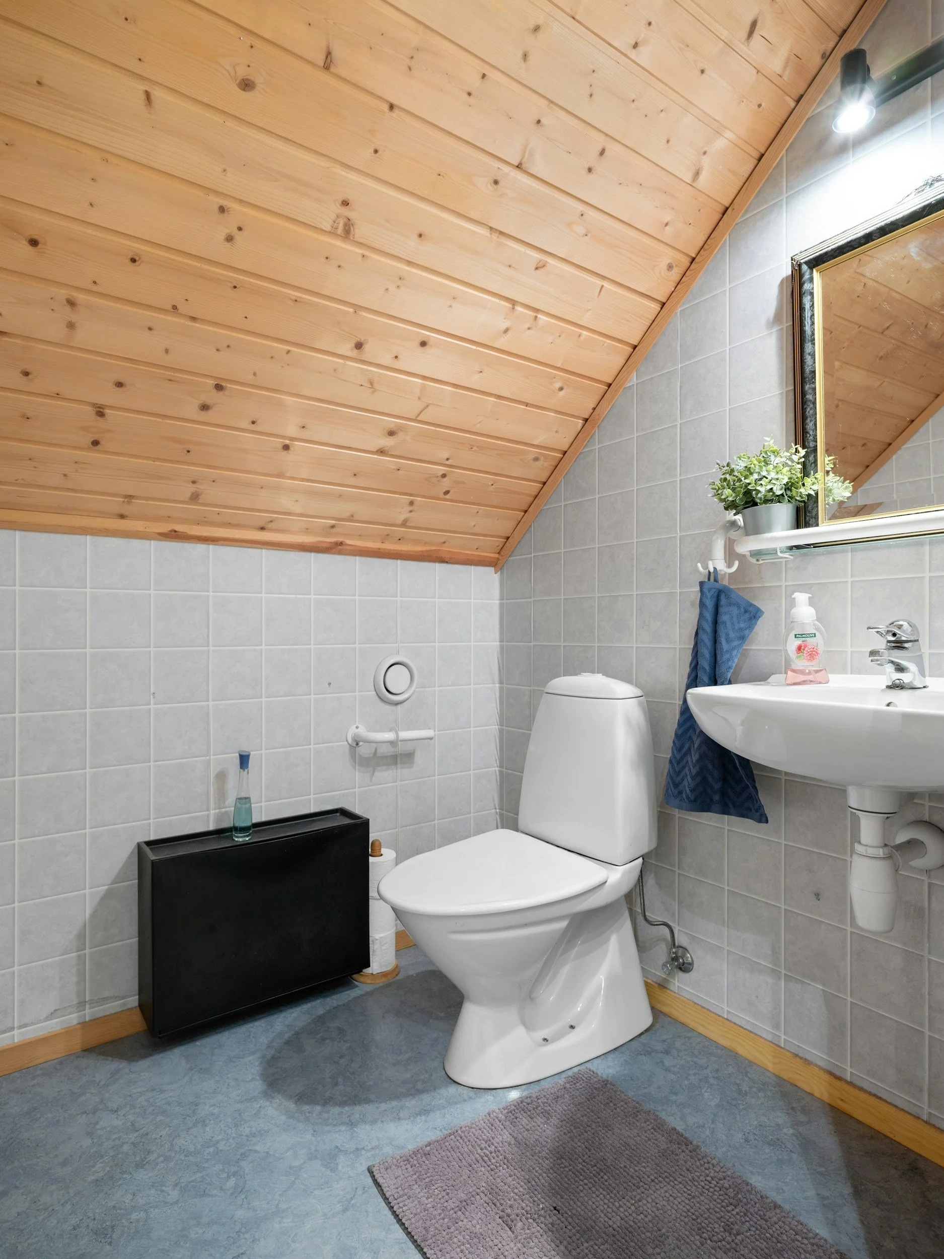 Kuva pienestä wc-tilasta remontin jälkeen, jossa on muovimatto.