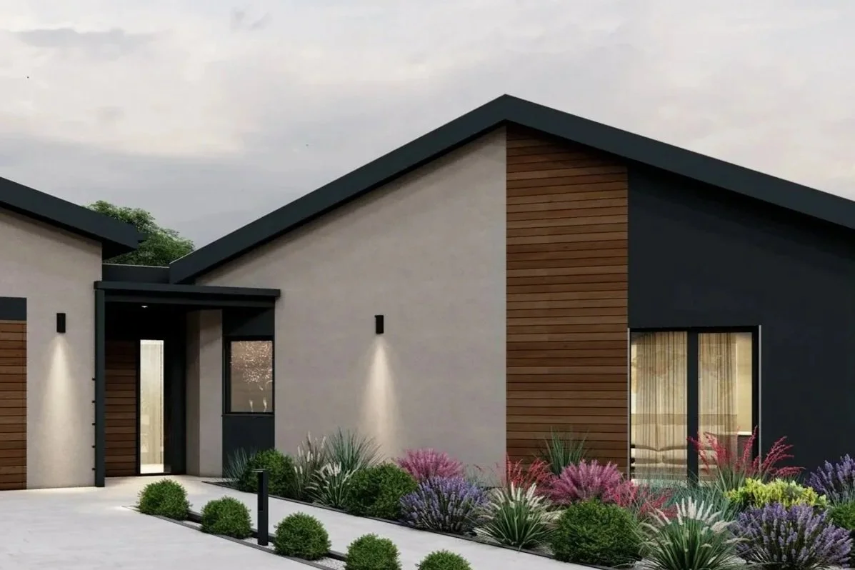 Modern house with black and wood exterior, front porch, landscaped garden with bushes and colorful plants, cloudy sky.