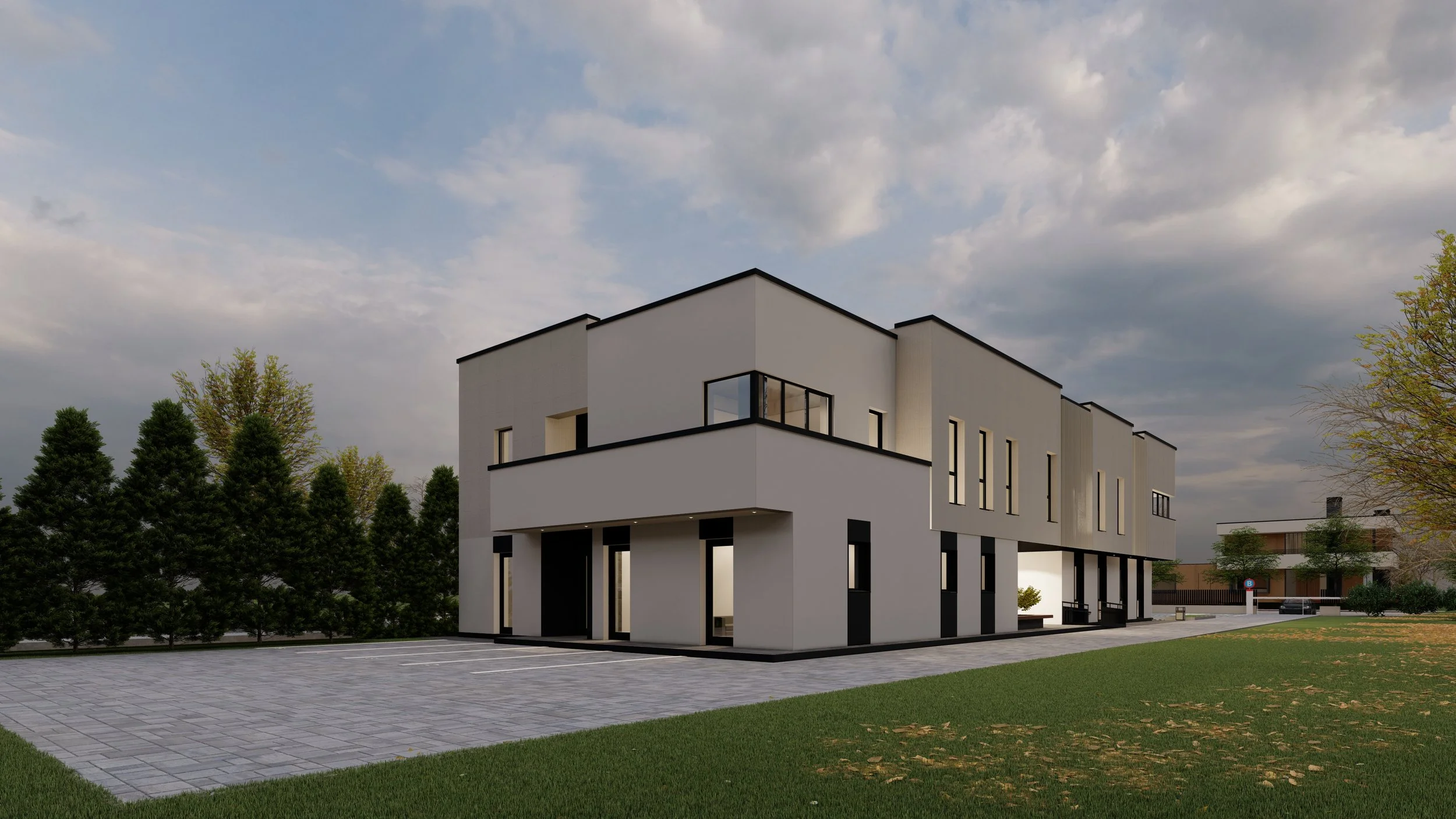 Modern white multi-story building with black accents, surrounded by green lawn and trees, under a cloudy sky.