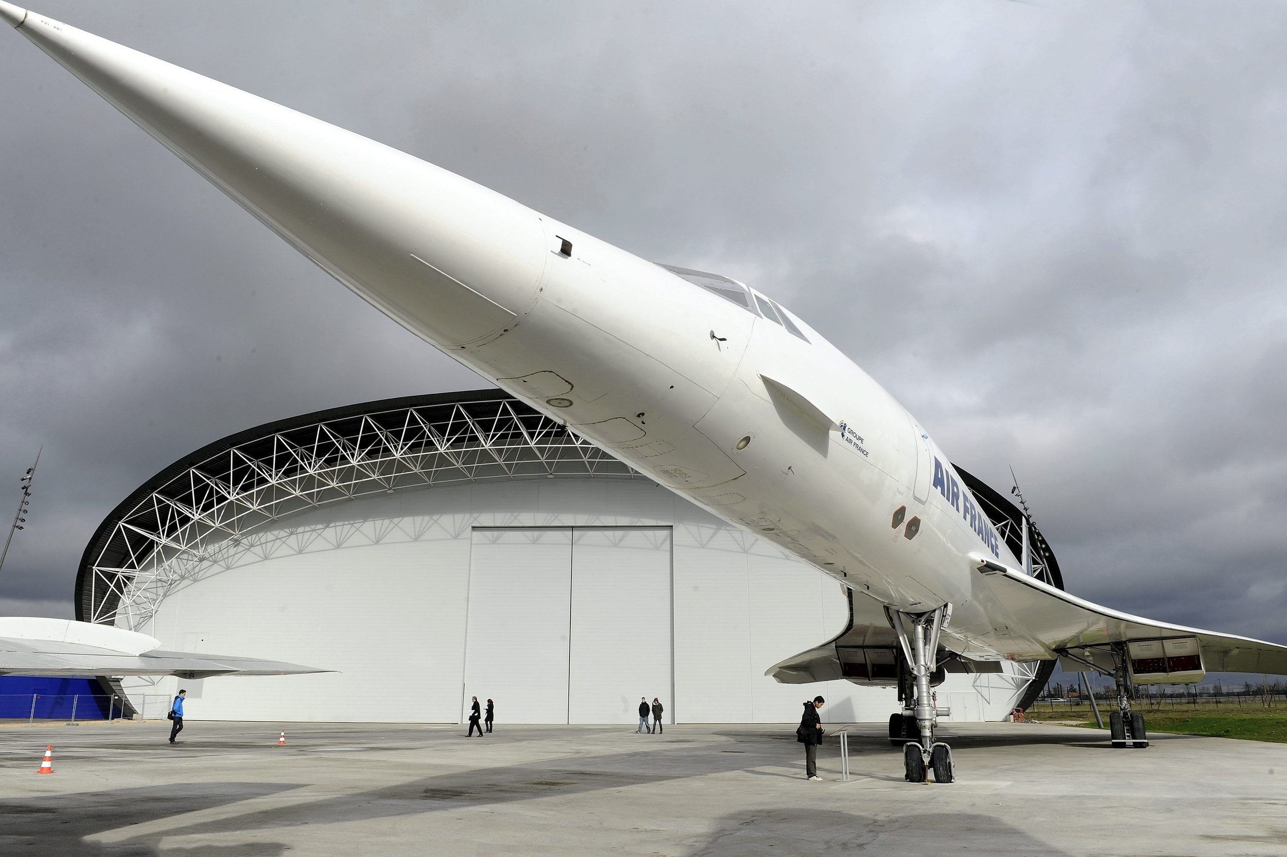 Un avion de l'Air France exposé en extérieur, avec un hangar en arrière-plan, sous un ciel nuageux.