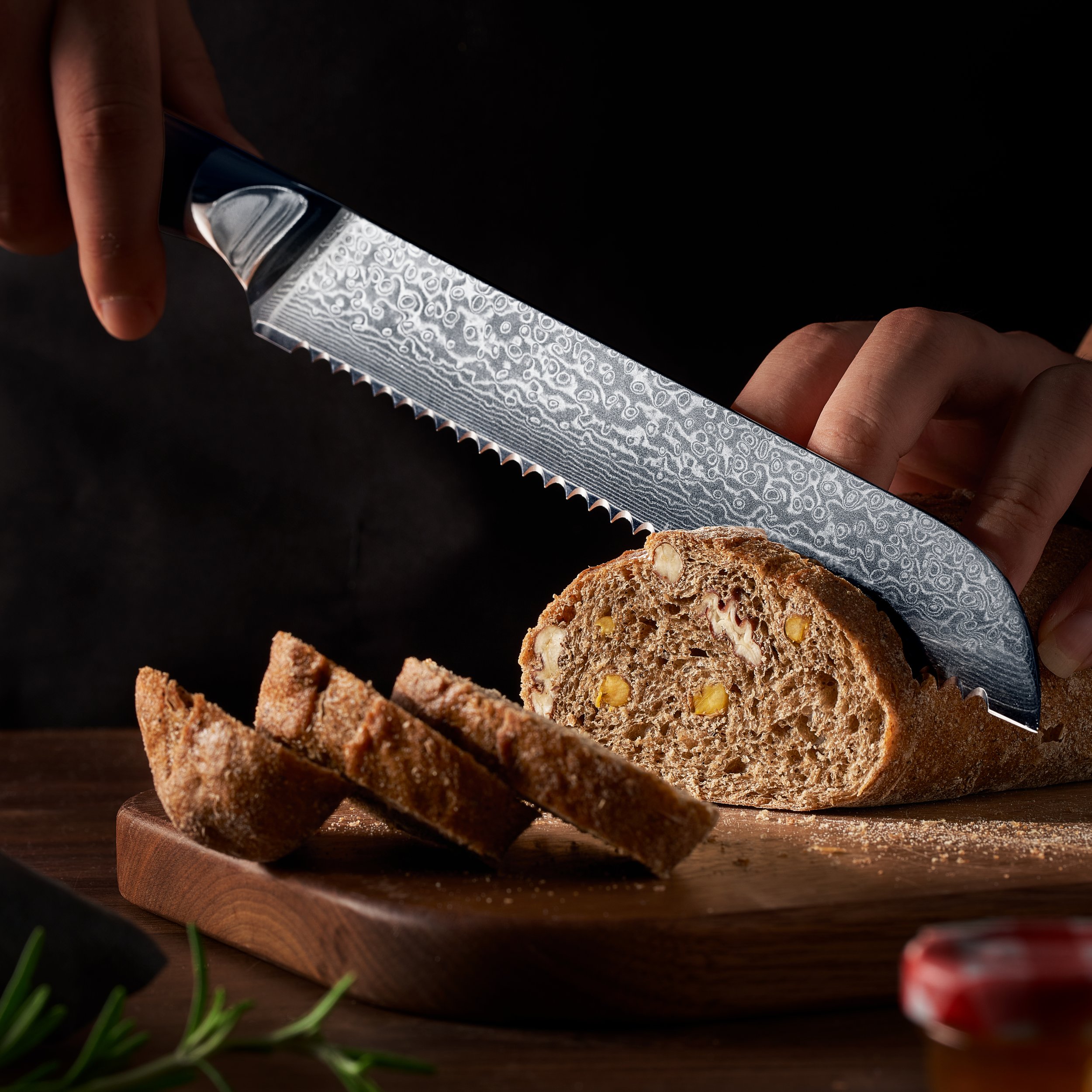 Person slicing a loaf of bread with a decorative knife on a wooden cutting board.