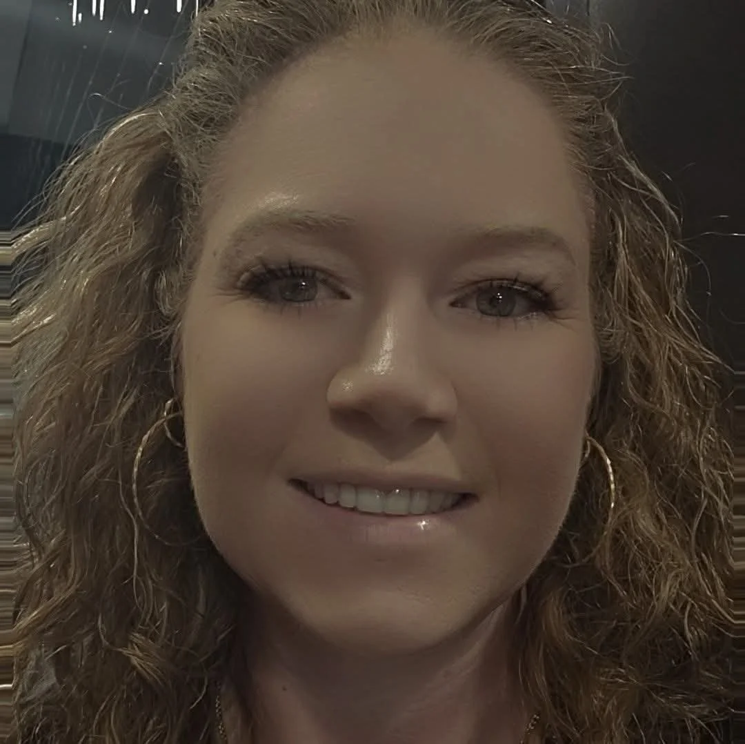 Close-up of a woman with curly hair smiling