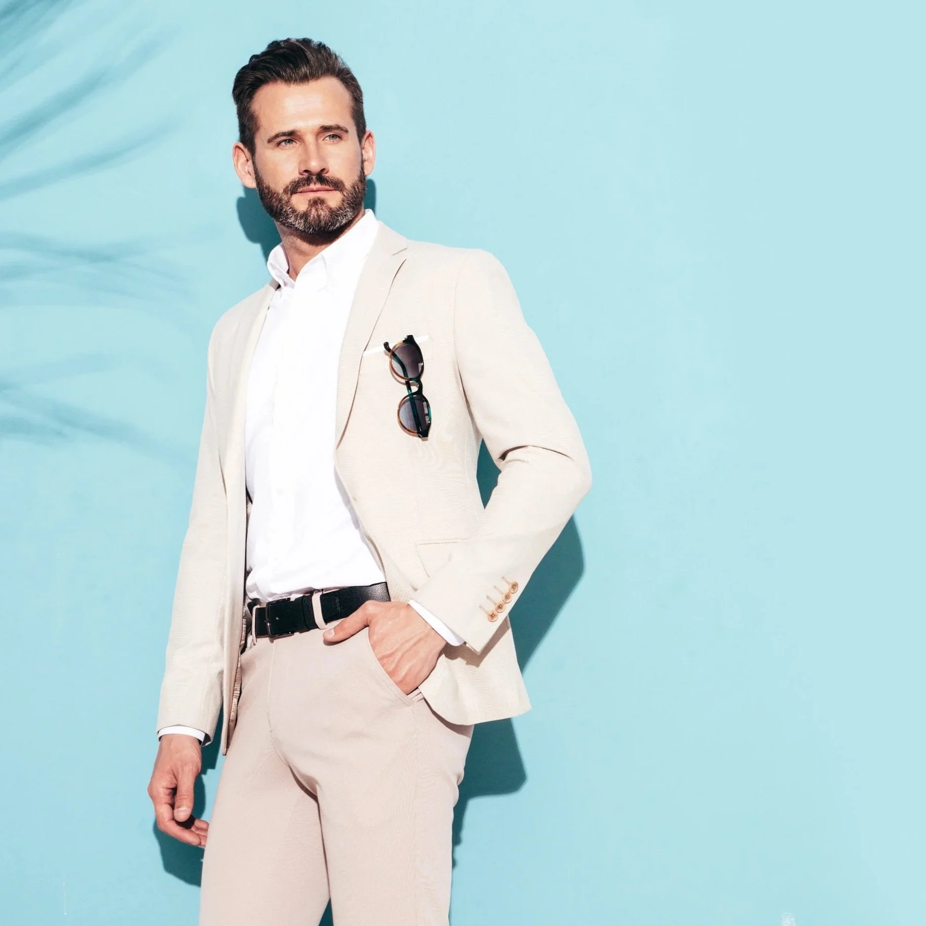 Mann i beige dress med lyseblå bakgrunn