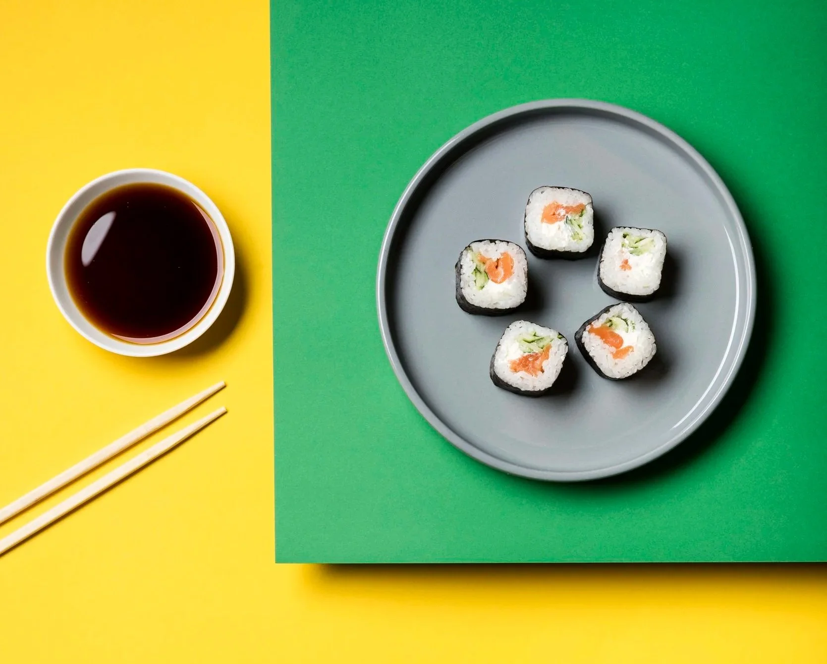 Tallerken med biter av maki, skål med soyasaus og spisepinner