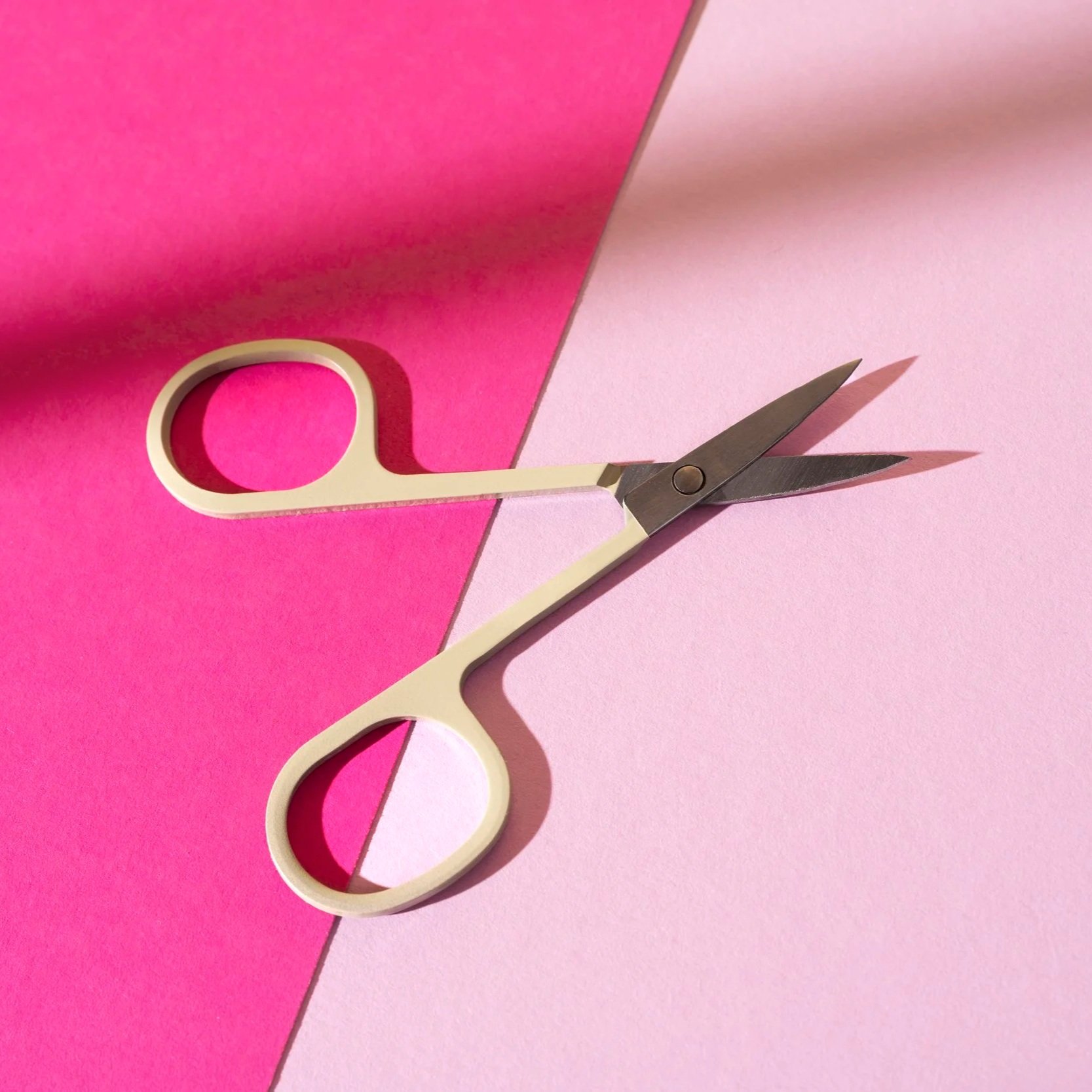 Hvit saks mot rosa bakgrunn