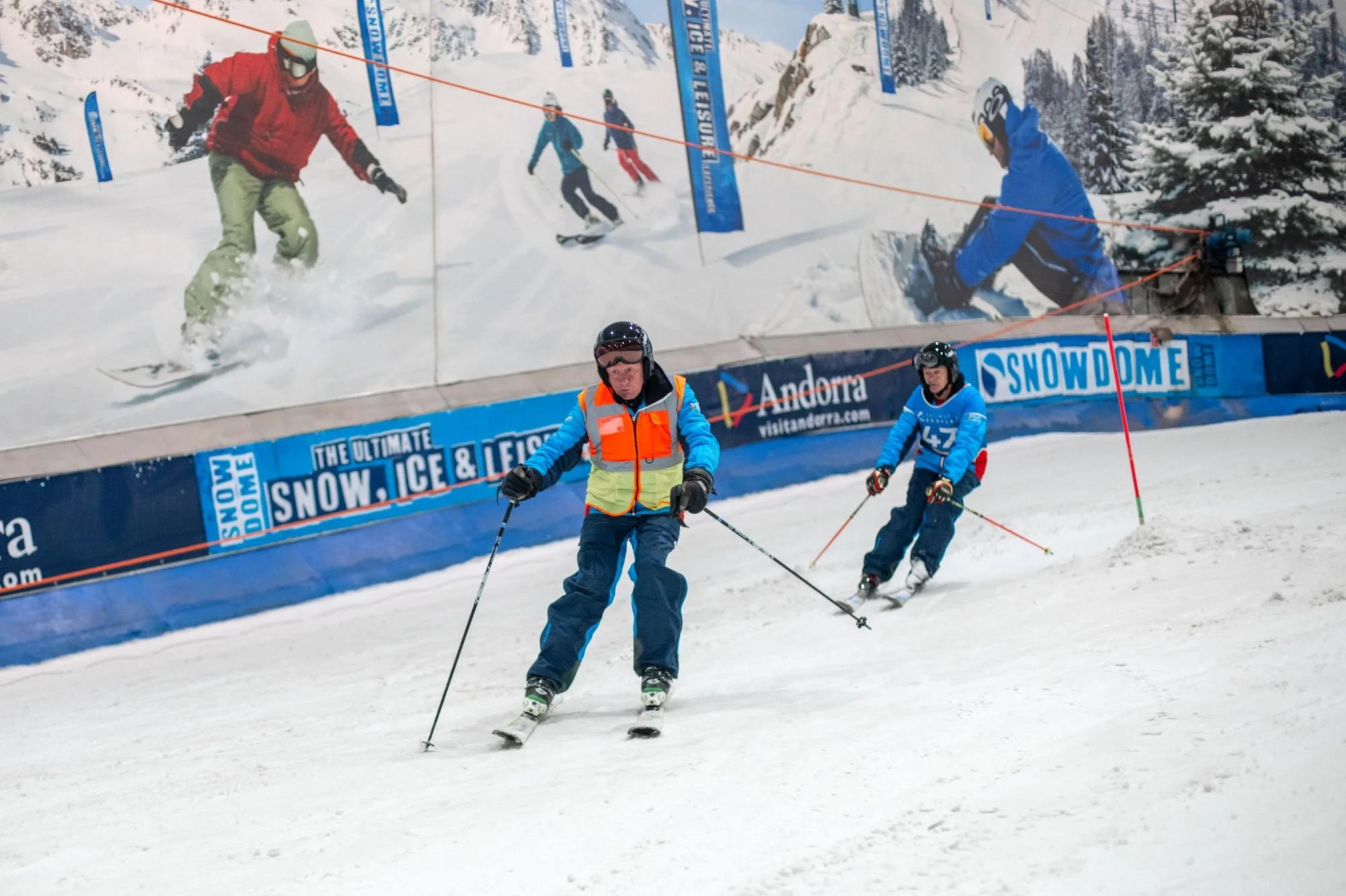 a visually impaired skier follows his guide down a race course at an indoor snow centre