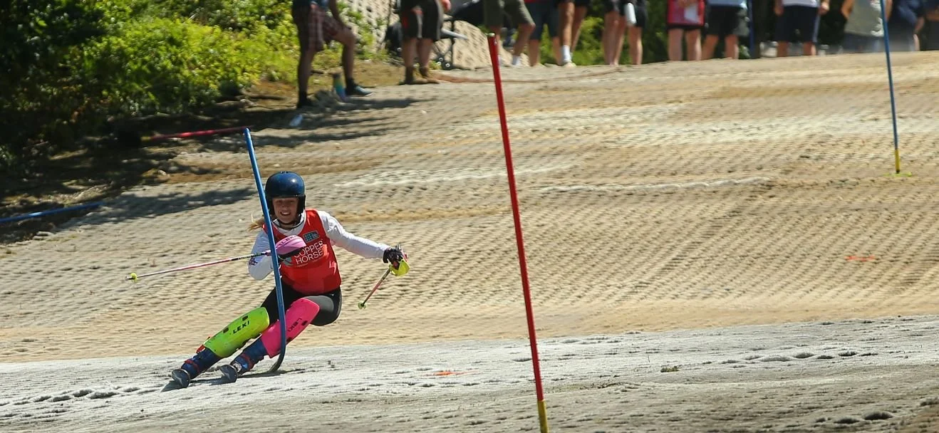 Girl racing down a slalom course on dry slope in England
