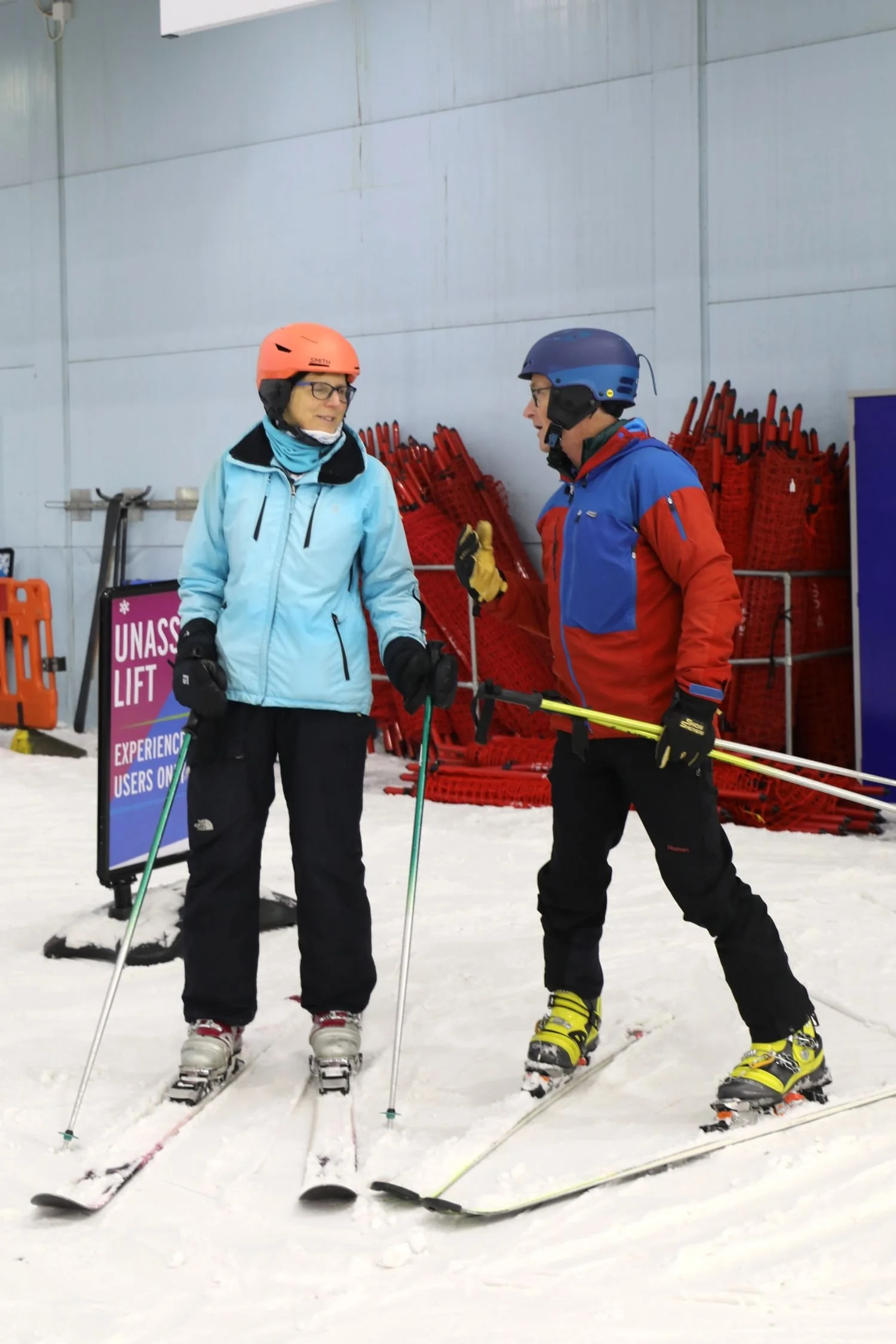 A male and female skier talking at an indoor snow centre in England