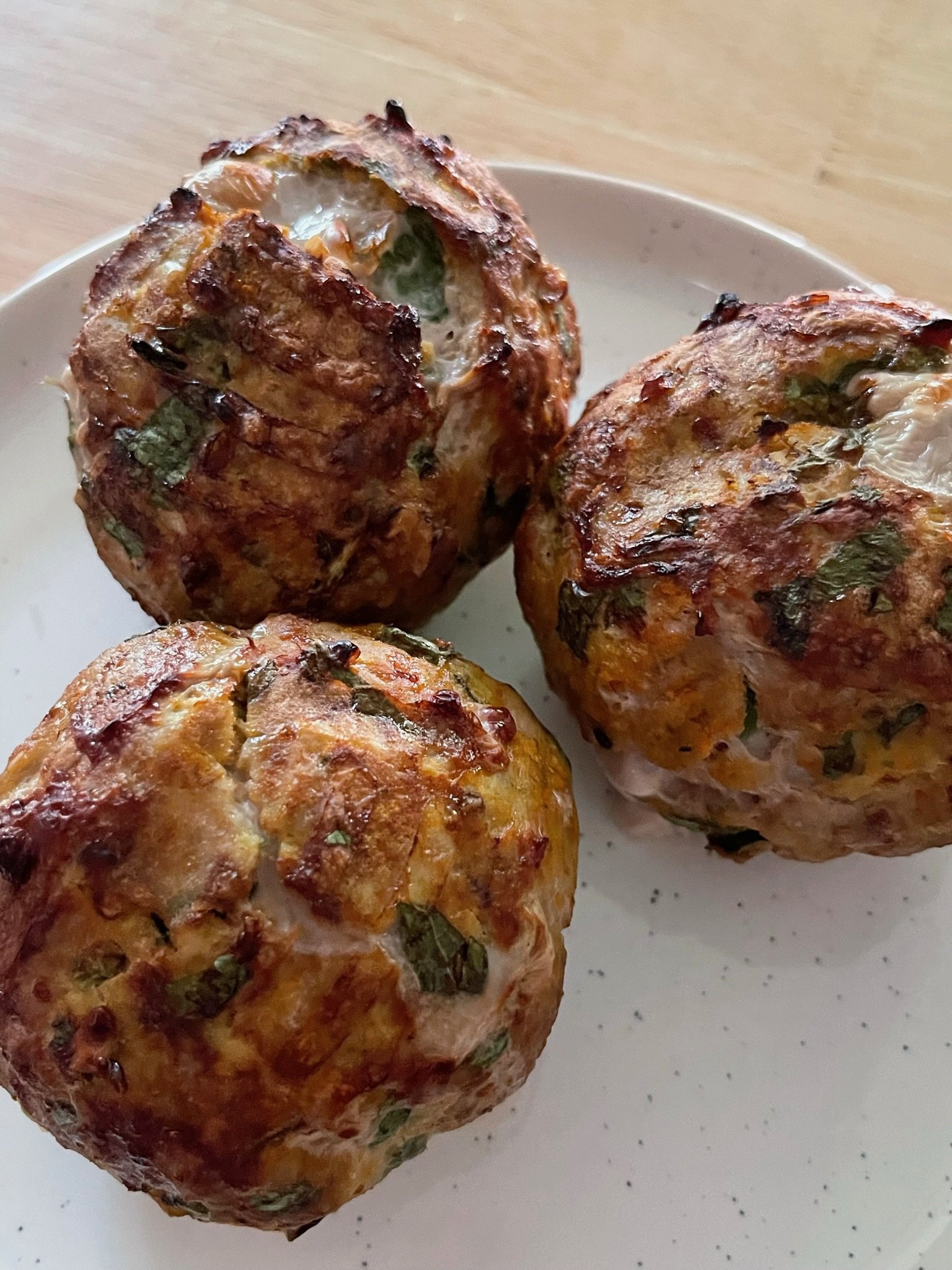 Three meat and vegetable meatballs on a white plate.