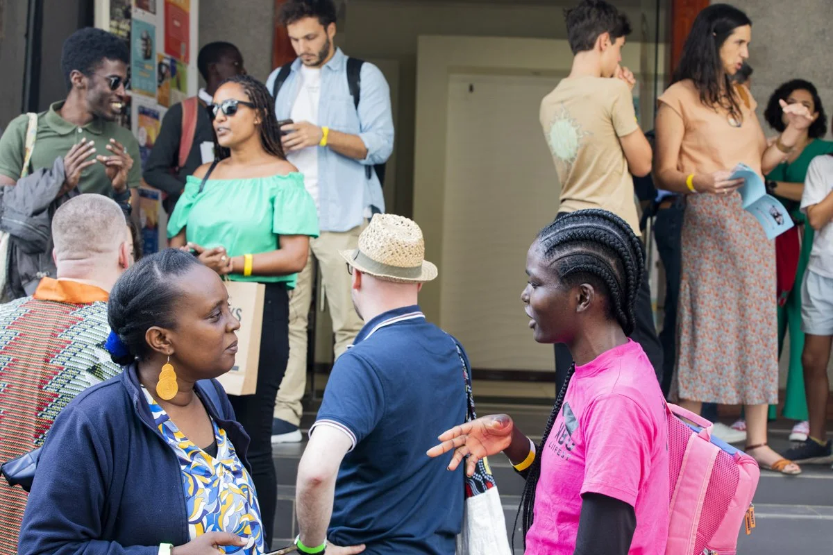 Group of diverse people socializing and walking in a public space or venue.