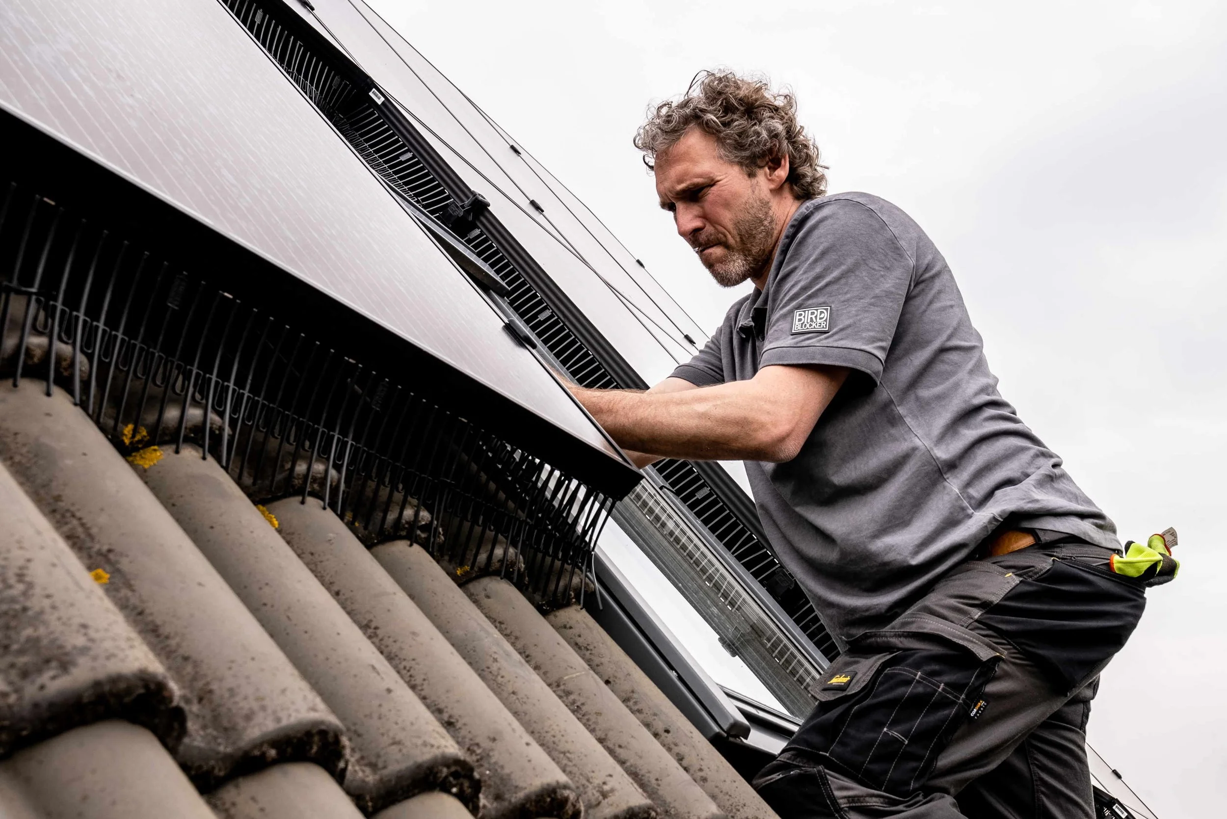 Man repareert zonnepanelen op een dak.