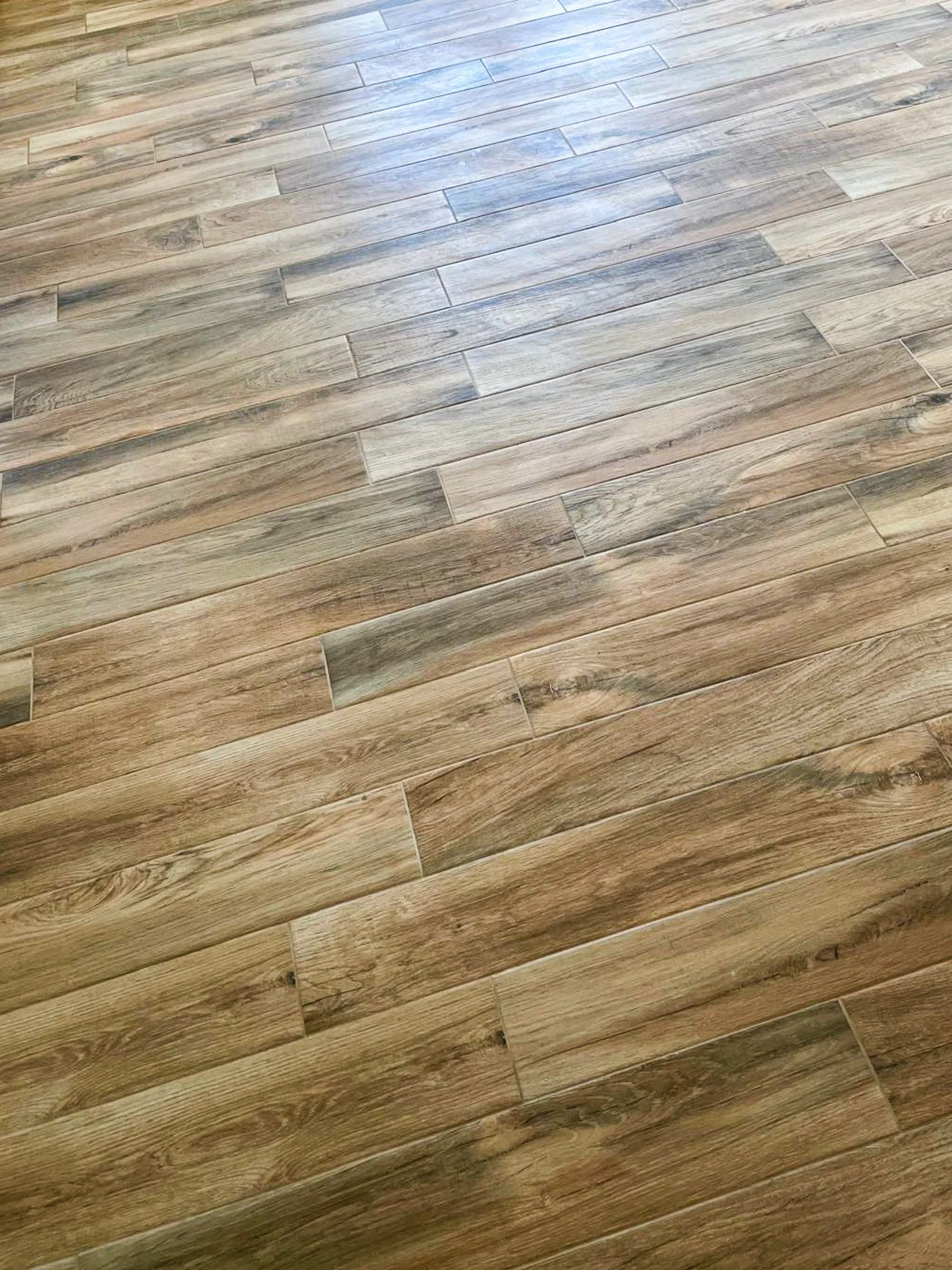 Plancher en bois clair avec un motif rectangulaire.