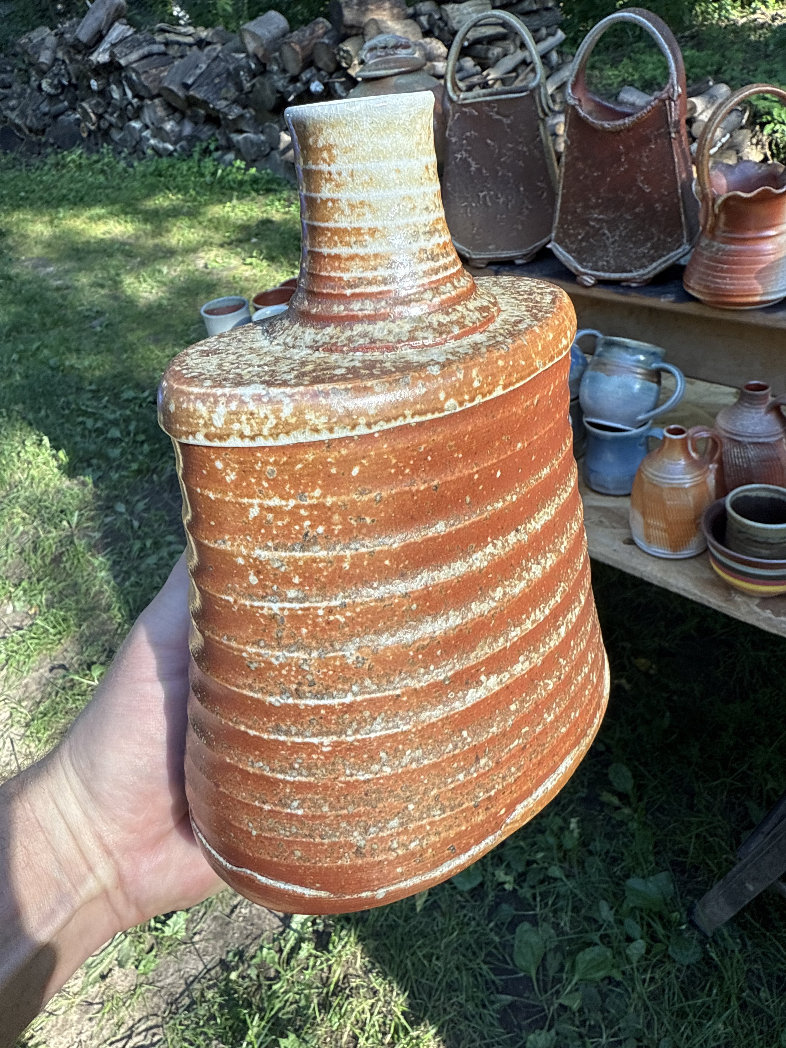 Wood-fired stoneware Whiskey Flask with natural ash buildup on a toasty orange clay