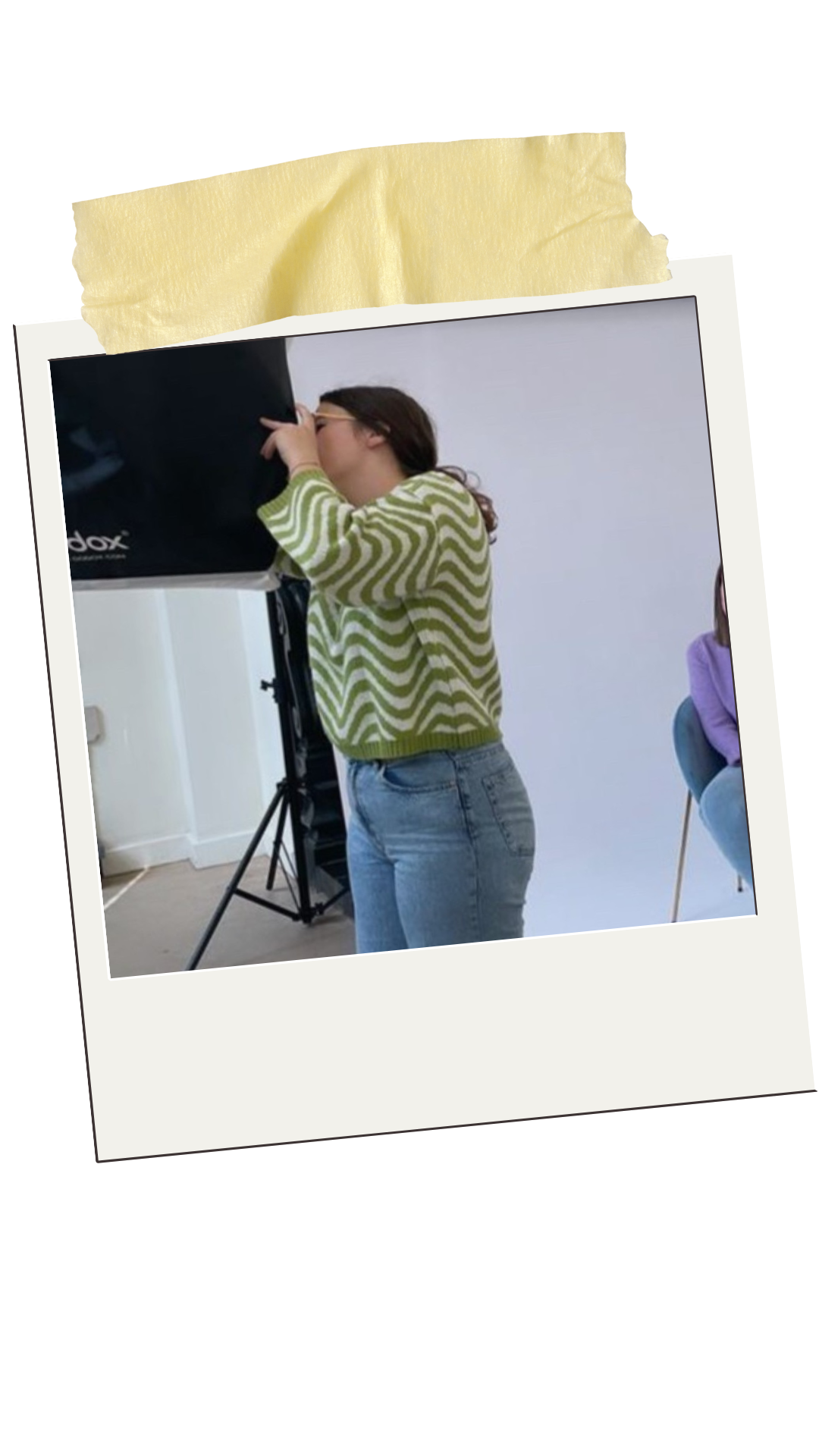 Een vrouw kijkt door een telescoop of camera, terwijl een andere persoon naast haar zit.