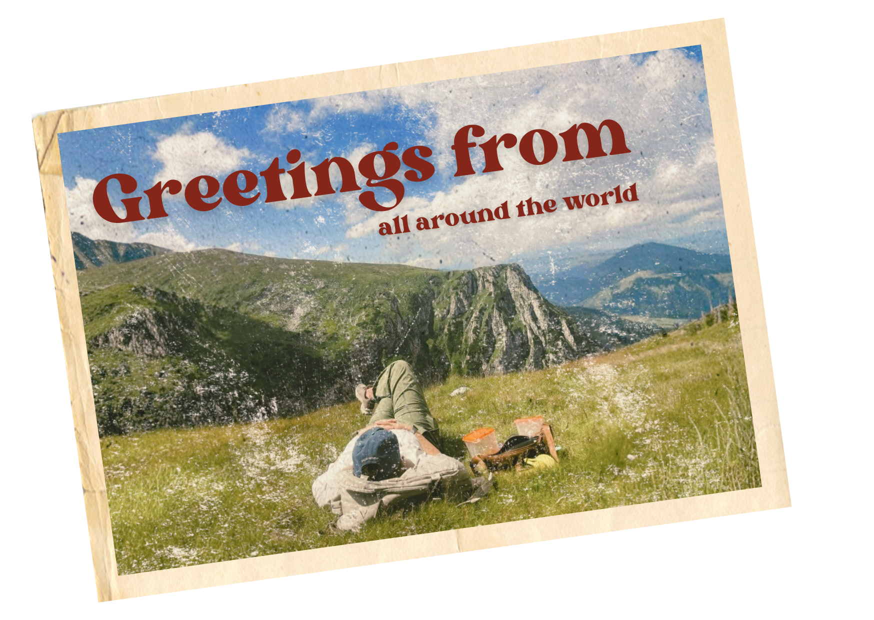 Een vakantiefoto van een persoon die op een grasveld ligt met uitzicht op bergen en een blauwe lucht met wolken, met een vintage stijl en tekst 'Greetings from all around the world' op de voorkant.