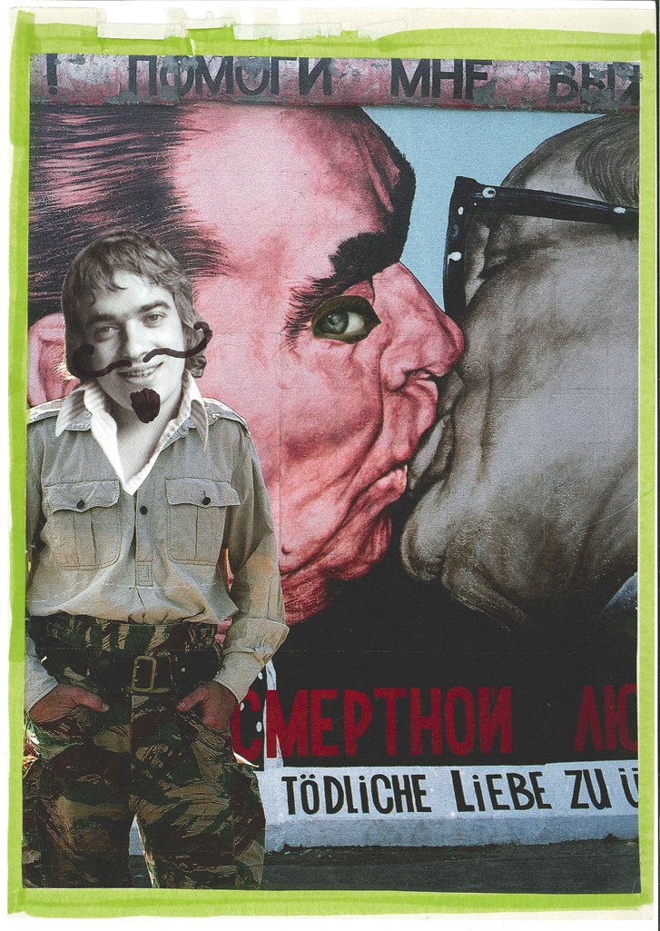 A man standing in front of a mural of two faces about to kiss. The man's face has been humorously edited to include a mustache and a beard, resembling the faces in the mural. The mural features a woman with an eye and a face, and a man with glasses, 