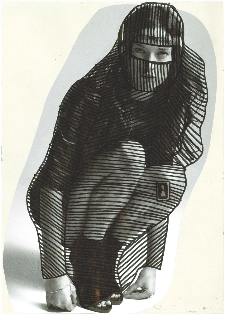A woman crouching down, wearing a black, striped, see-through dress with an attached face covering and a head covering, posing against a plain background.