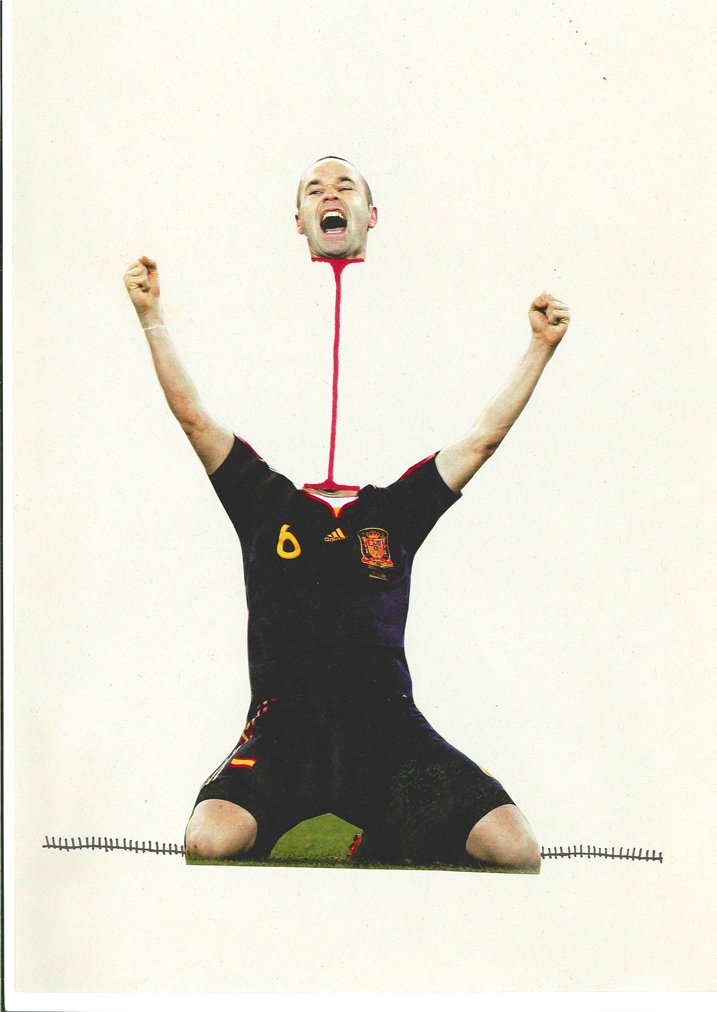 A cutout of a man kneeling on the ground wearing a soccer jersey with the number 6 and a Spain crest, with his head appearing to emerge from the top of the paper and his arms raised in victory.