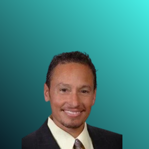 Portrait of a man wearing a suit and tie, smiling, with a light blue and teal gradient background.  Michael Desvigne