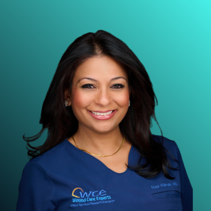 A woman wearing a white medical coat with WCC logo, smiling at the camera.
