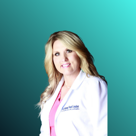 A woman in a white medical coat with a pink top underneath, smiling against a black background.
