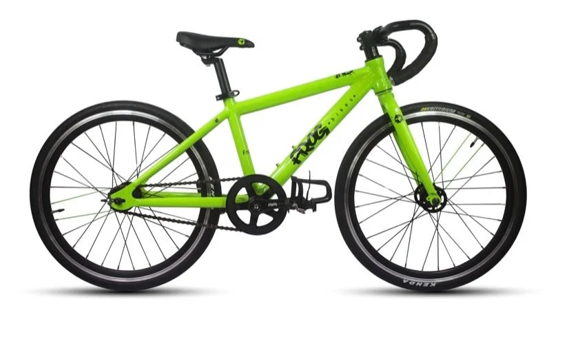 Bright green Frog children's bicycle with black handlebars, black saddle, and black tires inside